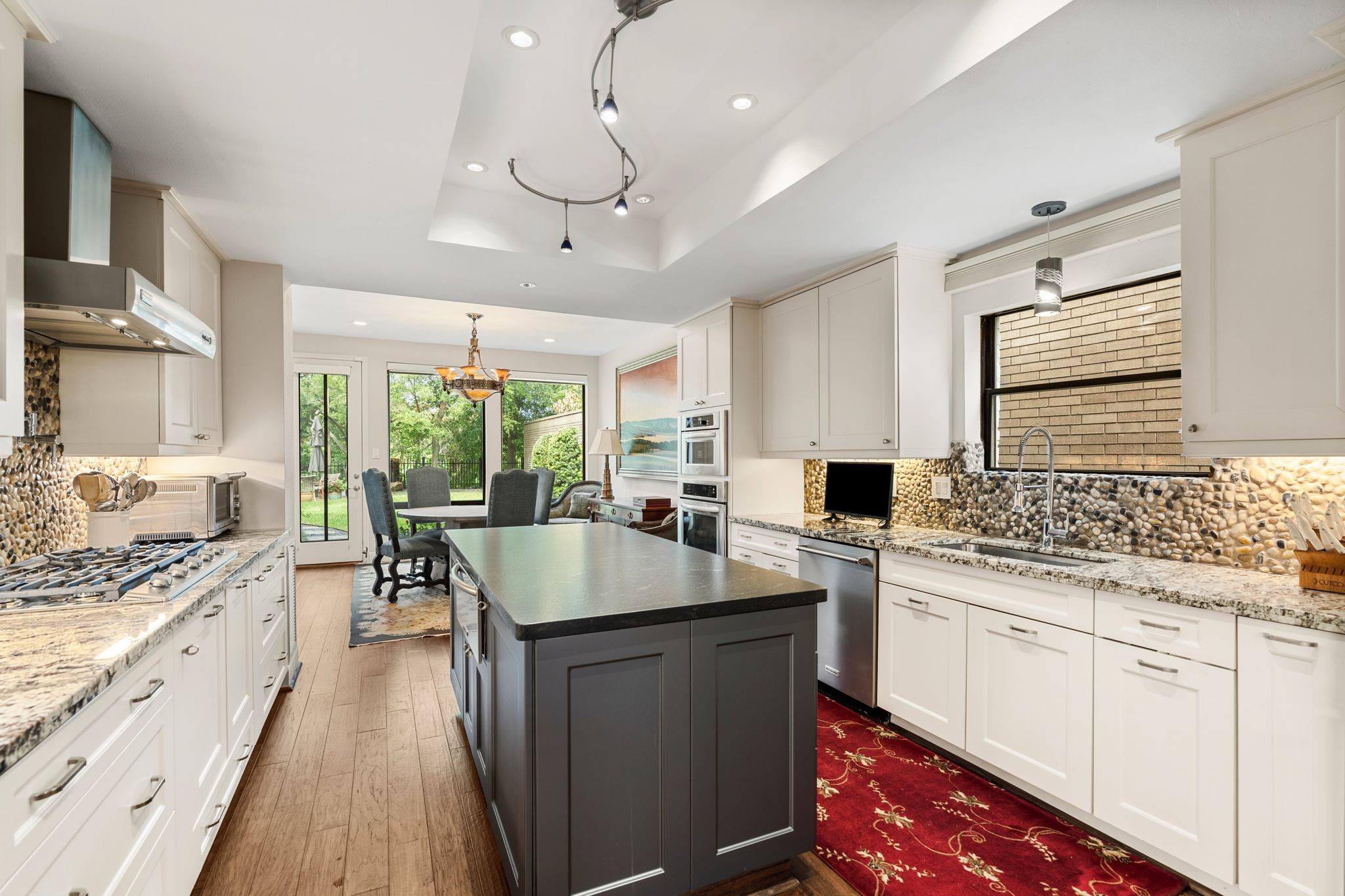 Generous work surfaces, a central island and extensive drawer storage provide a practical kitchen layout, complemented by stainless appliances and undercabinet lighting.