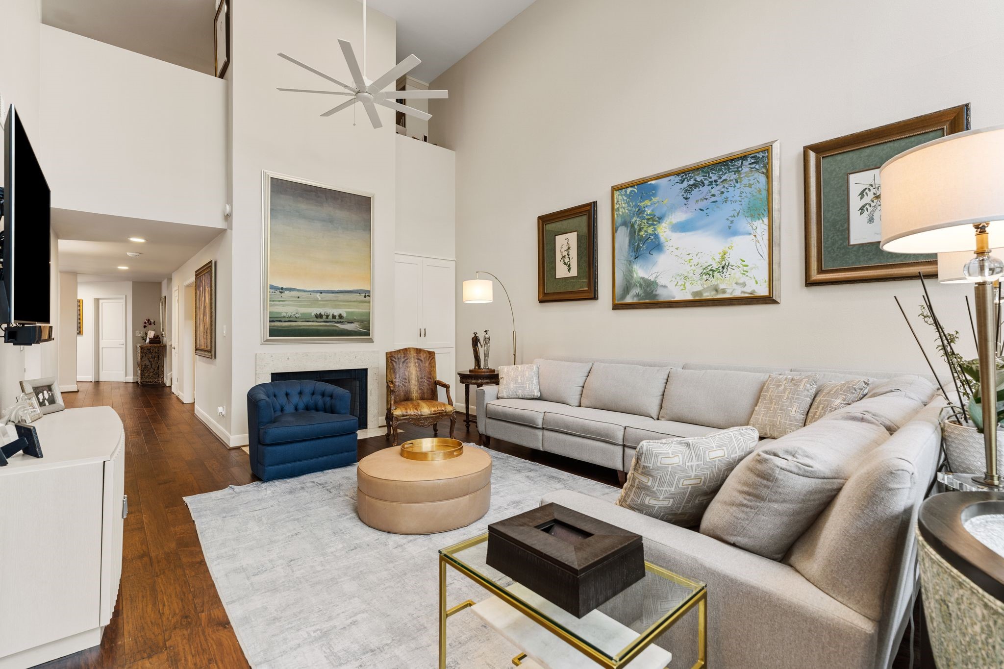 A fireplace and built-in cabinetry anchor the living room, while soaring walls provide generous space to display artwork.
