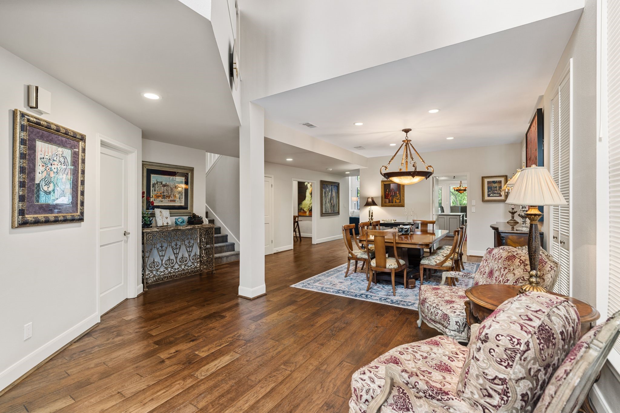 The soaring entry opens to a generous dining area, with warm wood flooring connecting the main gathering spaces.