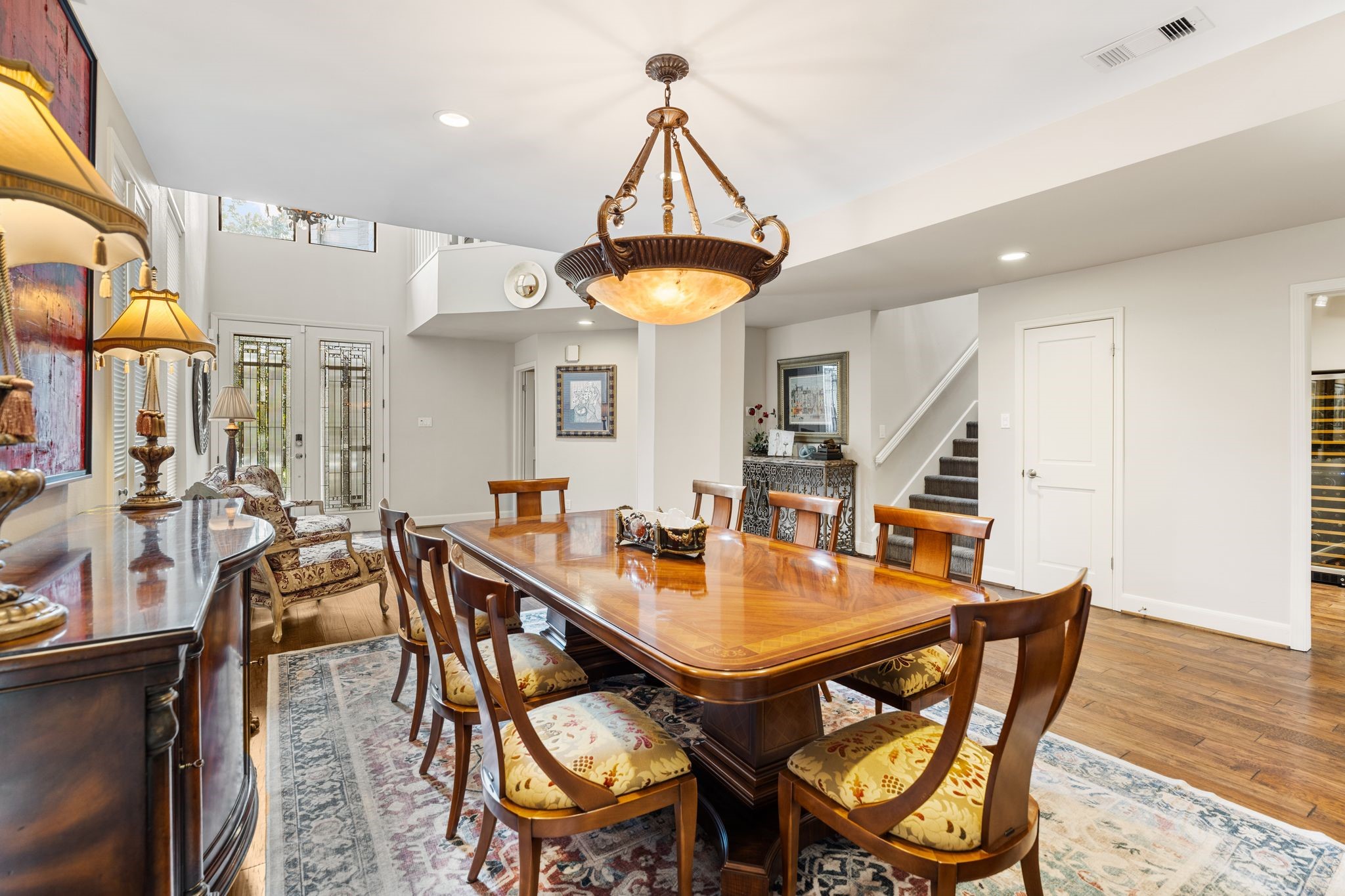 This view toward the entry highlights decorative glass double doors, upper windows and the open connection between the foyer and dining area.