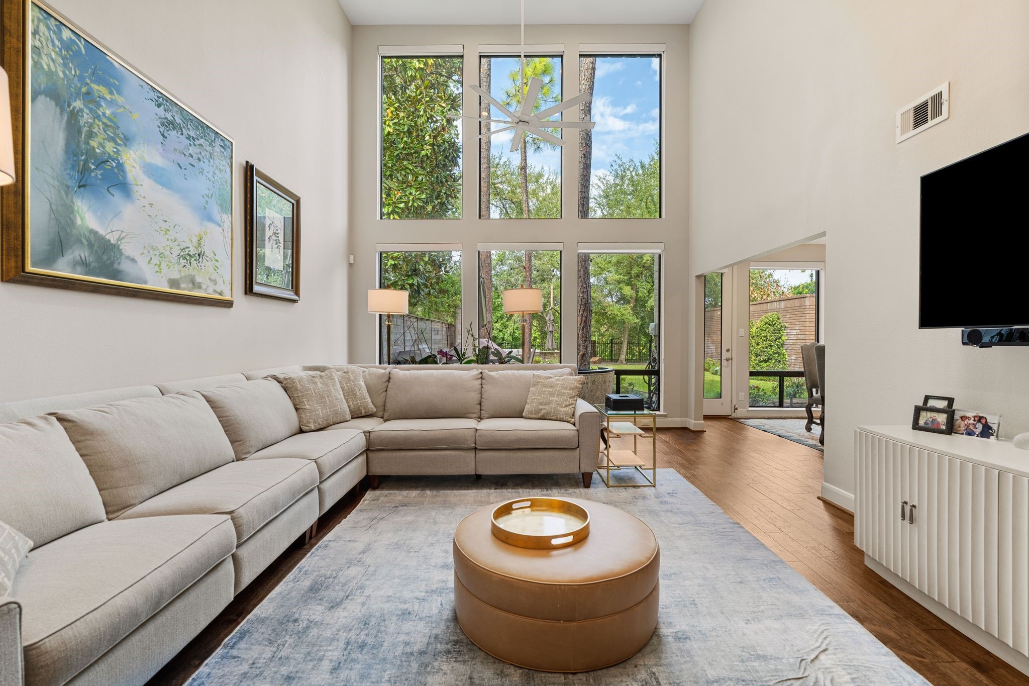 The airy living room offers generous seating space and an open connection to the breakfast area, with outdoor access nearby.