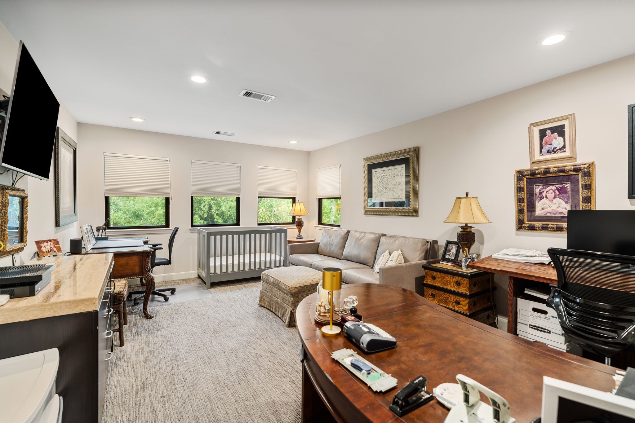 Currently arranged as a home office, this versatile upstairs room offers multiple windows and space for both workstations and comfortable seating.