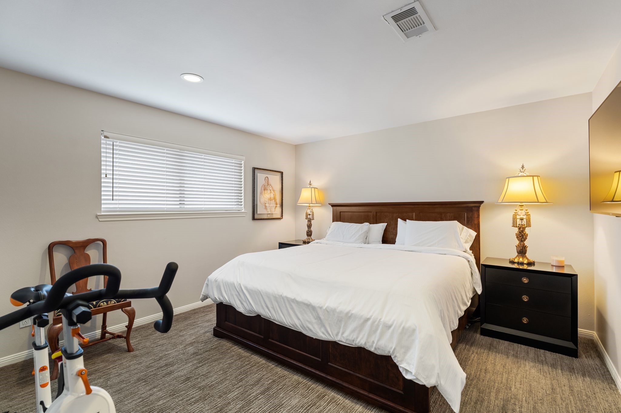This secondary bedroom offers neutral finishes, carpeting and comfortable space for a large bed, nightstands and additional furnishings.
