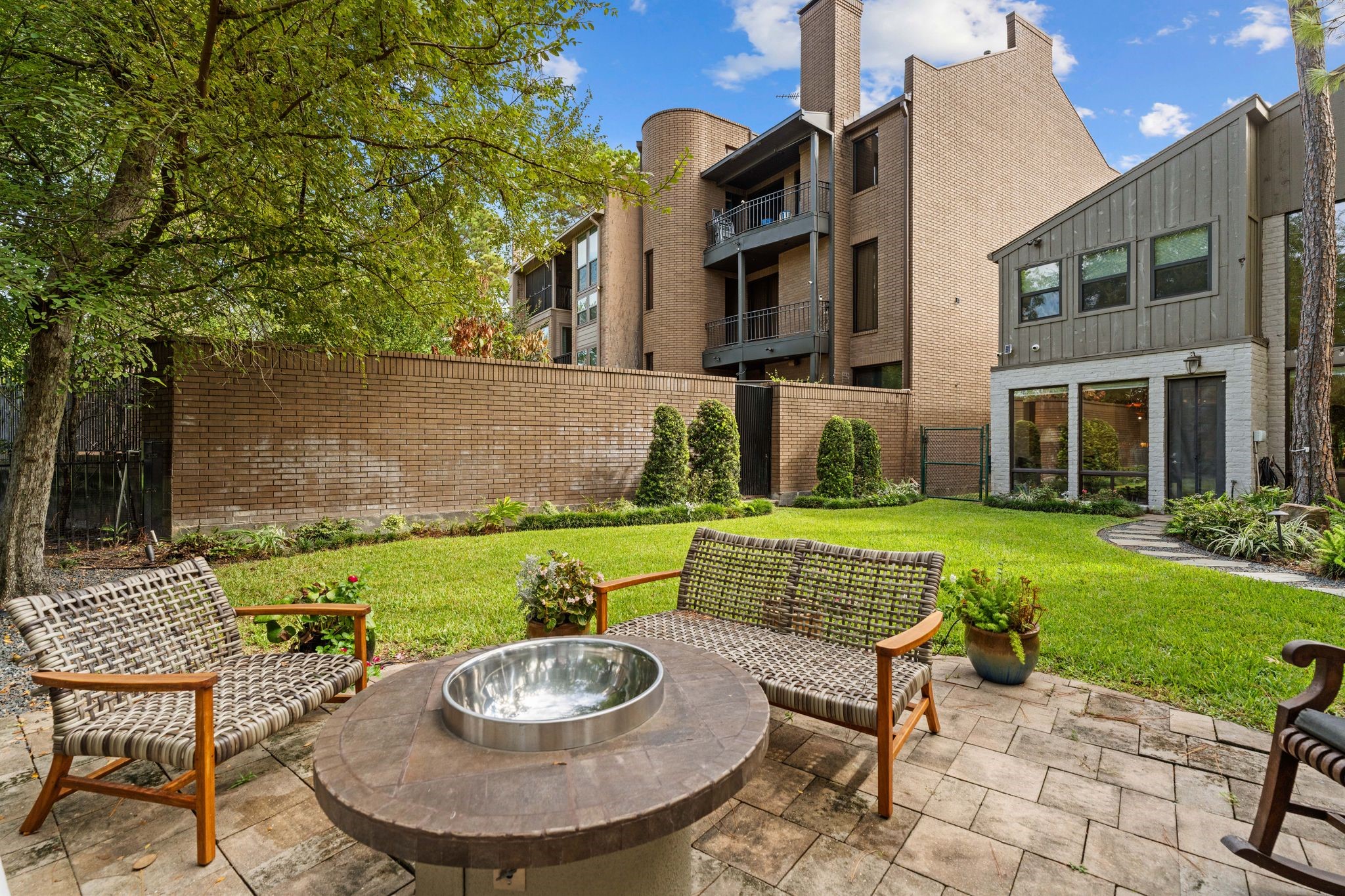 Looking back from the sitting patio, this view highlights the lawn, landscaped borders and rear of the home.