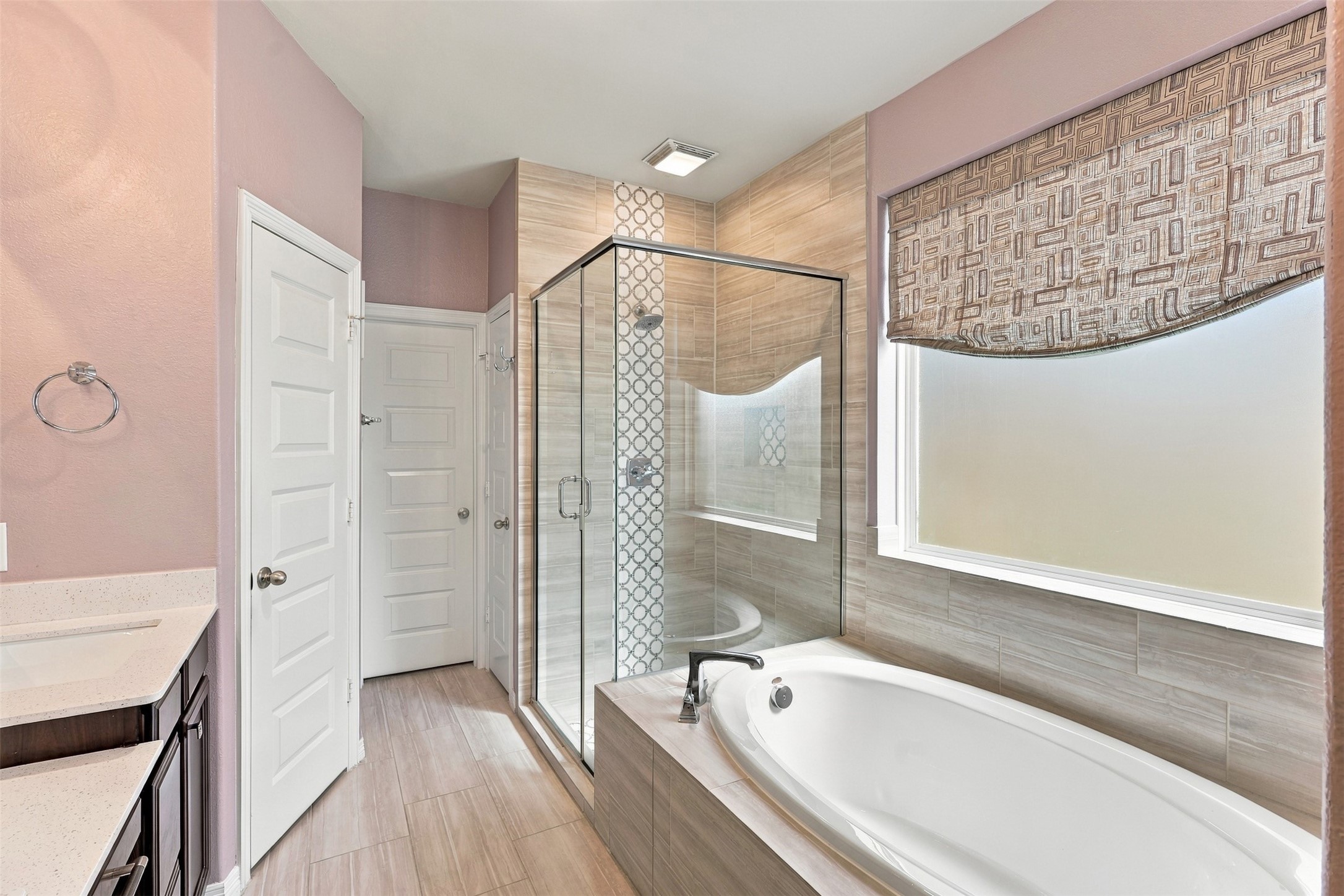 Your own little retreat awaits! This inviting primary bathroom features a relaxing soaking tub, separate glass-enclosed shower, and a decorative window treatment that adds a touch of elegance. With its soft colors and thoughtful finishes, this space makes everyday routines feel a little more special.