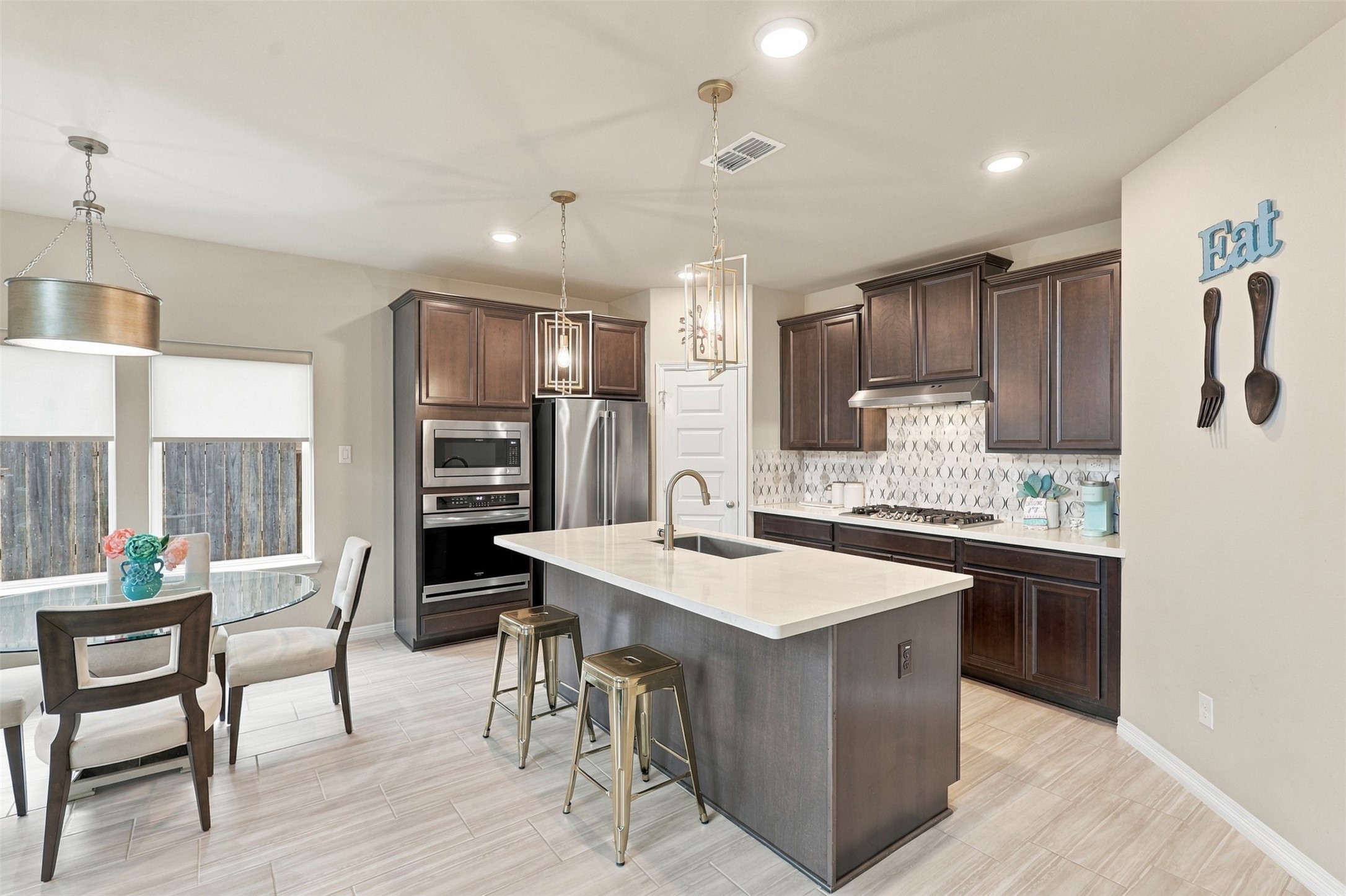 WOW! A GOURMET KITCHEN THAT WILL STEAL YOUR HEART! Prepare to FALL IN LOVE with this stunning culinary masterpiece, where rich, elegant dark cabinetry beautifully contrasts with gorgeous quartz countertops and gleaming stainless-steel appliances! The magnificent, oversized island with inviting seating creates the PERFECT gathering spot for morning coffee, casual meals, and wonderful conversations!