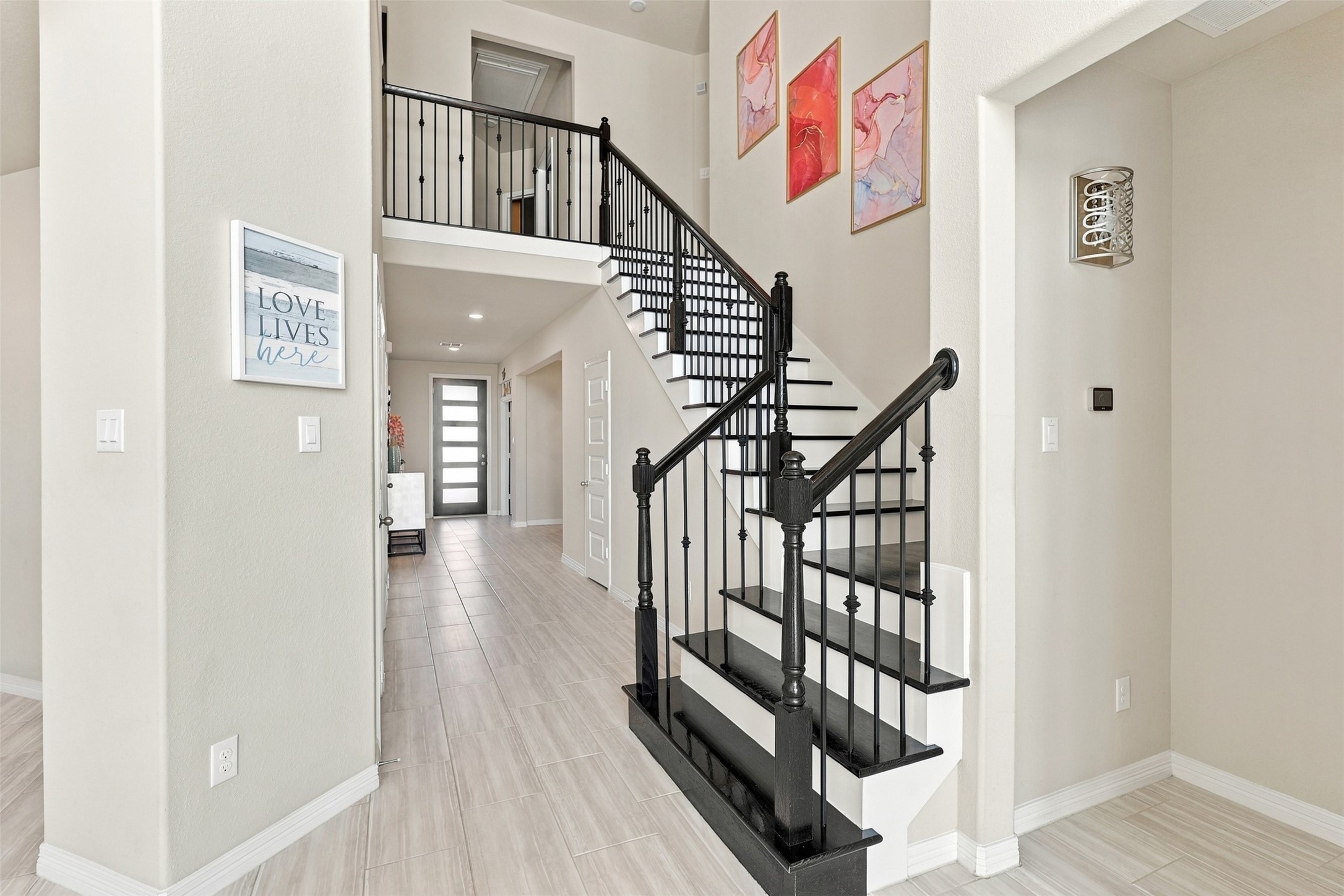 LET'S DISCOVER WHAT AWAITS UPSTAIRS! WOW! This BREATHTAKING sweeping staircase is a true architectural SHOWSTOPPER, featuring gorgeous wood steps and elegant decorative iron railings that add timeless beauty and sophistication! As you make your way upstairs, prepare to be AMAZED by even more incredible living spaces, thoughtful design, and wonderful surprises!