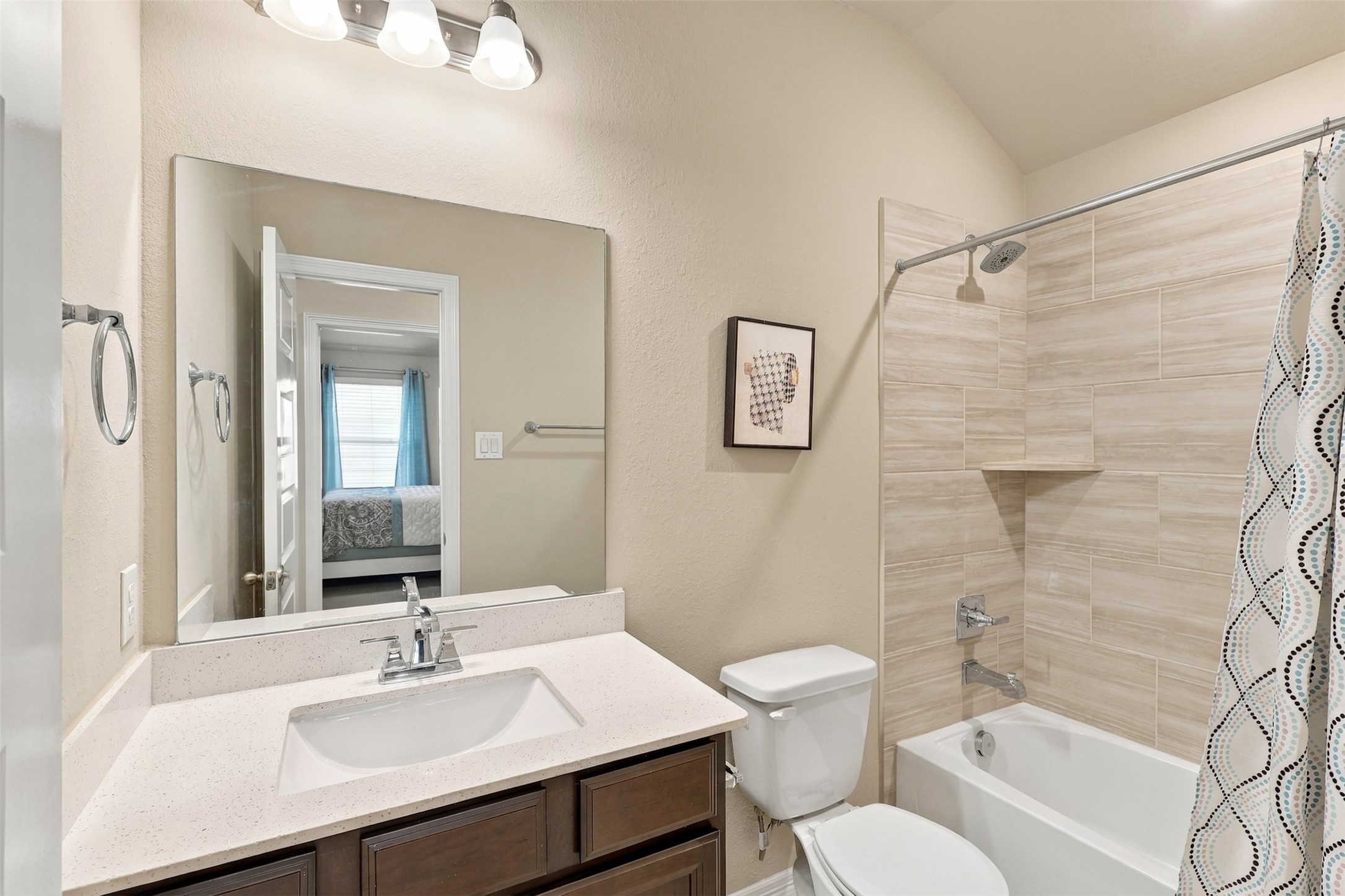 WOW! EVEN THE GUEST BATHROOM IS DESIGNED TO IMPRESS! Gorgeous upgraded QUARTZ countertops with a stylish backsplash, a deep undermount sink, and beautiful designer tile surrounding the tub and shower create a stunning blend of elegance and everyday comfort! And don't overlook those VANITY DRAWERS! Unlike many homes with limited bathroom storage, this beauty offers convenient drawers to keep your essentials!