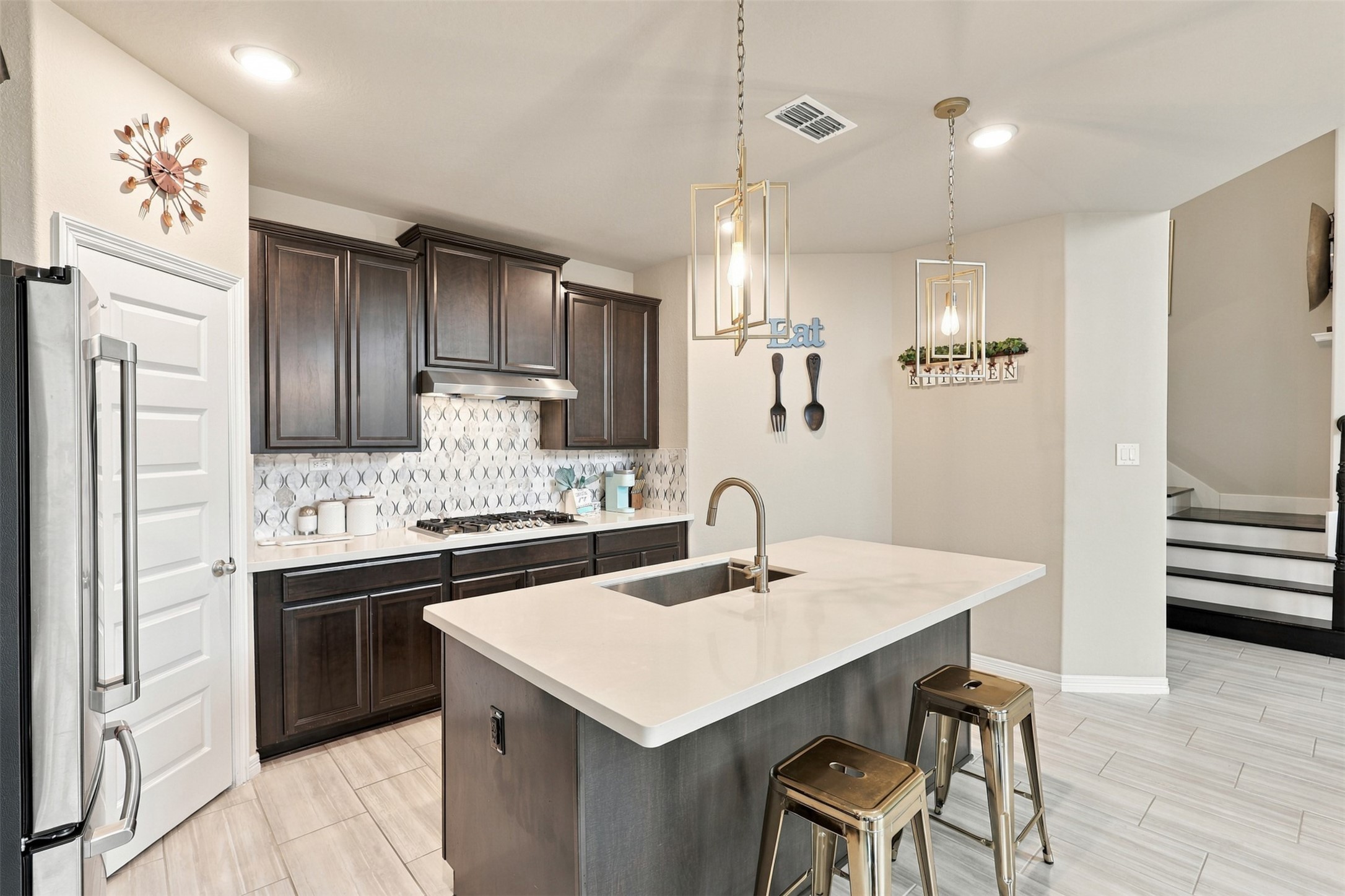 GOURMET KITCHEN DESIGNED TO DAZZLE! Prepare to FALL IN LOVE with this spectacular space where luxury, beauty, and functionality come together! The MASSIVE center island creates the perfect gathering place, while the impressive 5-burner gas cooktop makes preparing your favorite meals a delight! Gorgeous designer pendant lighting adds a touch of elegance, while the stunning, crisp tile backsplash creates that unforgettable WOW FACTOR!