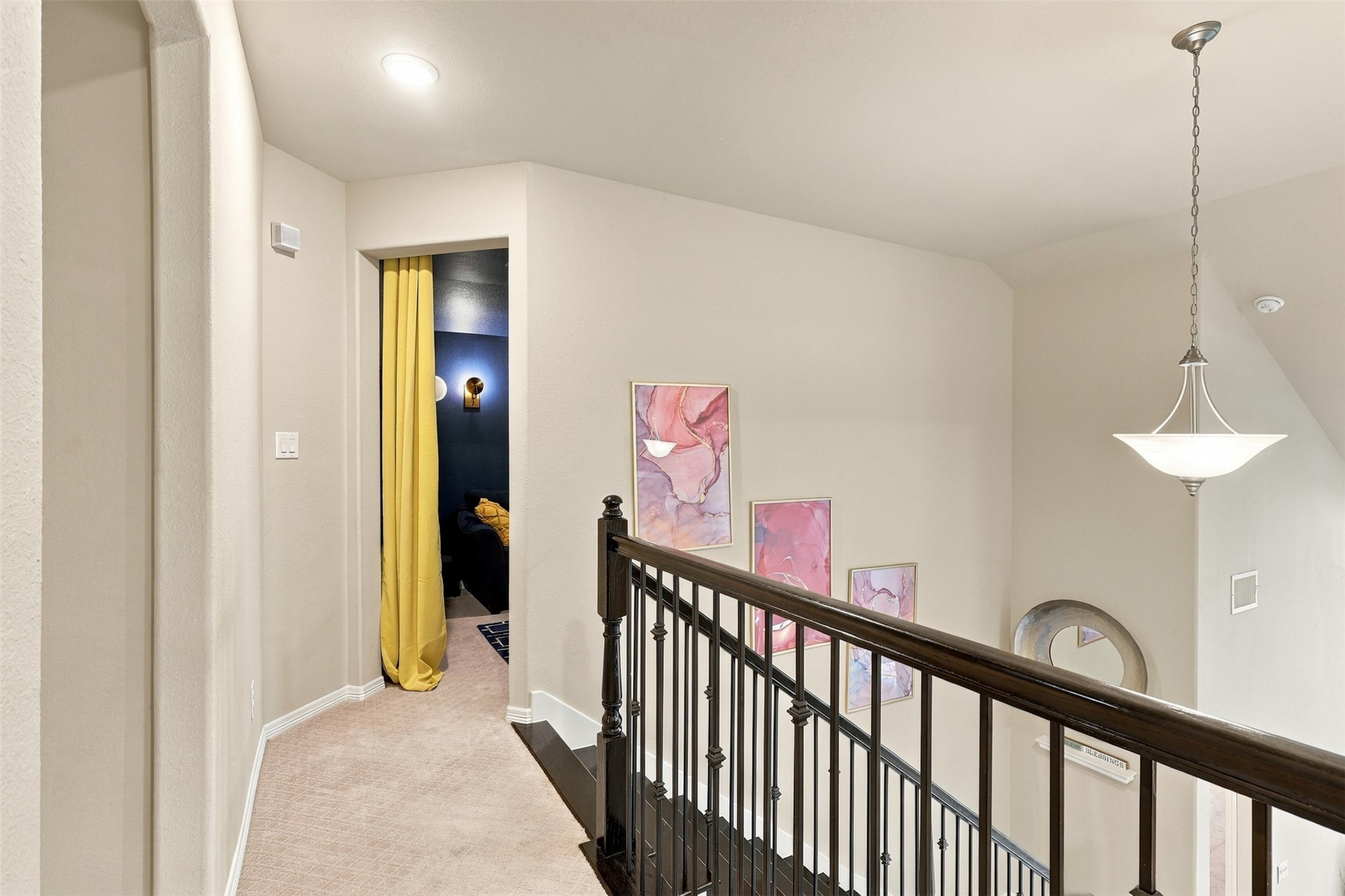 A bright and welcoming upstairs landing offers a charming transition between the home's upper-level spaces. Soft neutral finishes, plush carpeting, and a stylish pendant light create a warm, comfortable atmosphere.