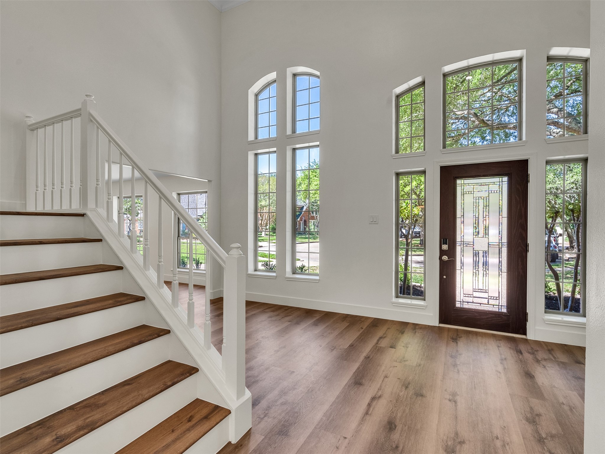 Bright, open entryway with high ceilings and large windows, enhancing natural light