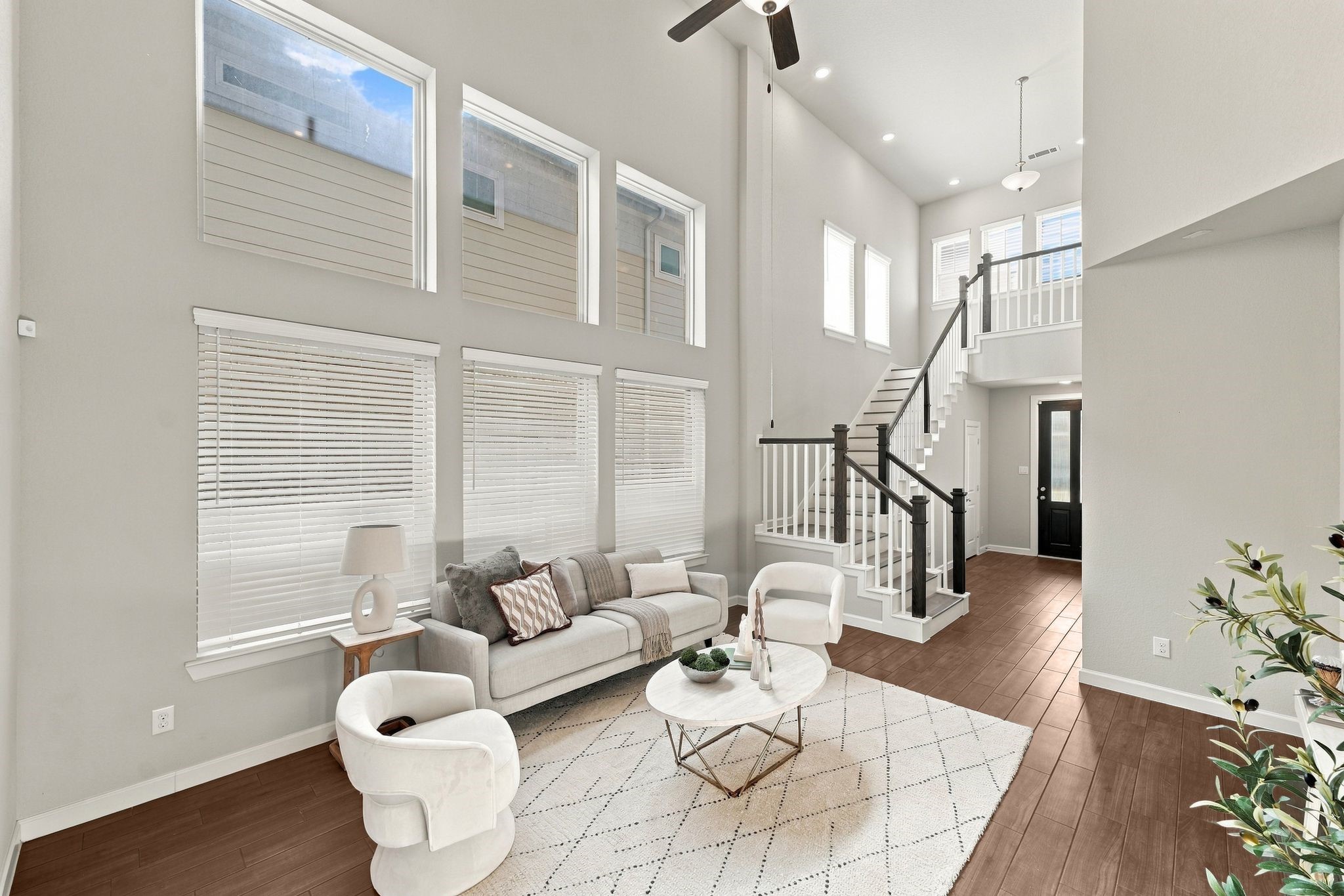 Two story windows pour light into a living room built for first impressions, right off the entry.