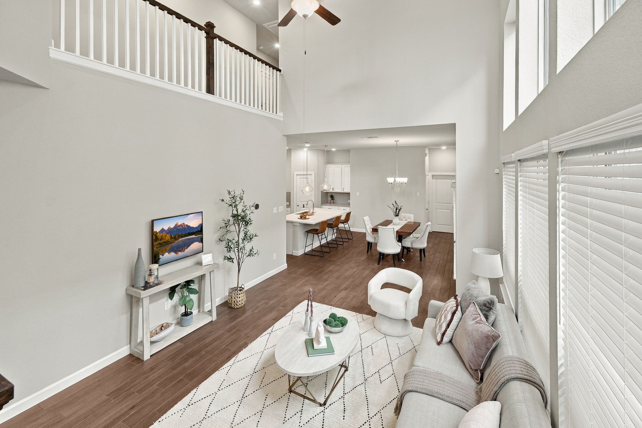 From the loft, the whole first floor unfolds, kitchen, dining, and living room in one line of sight.