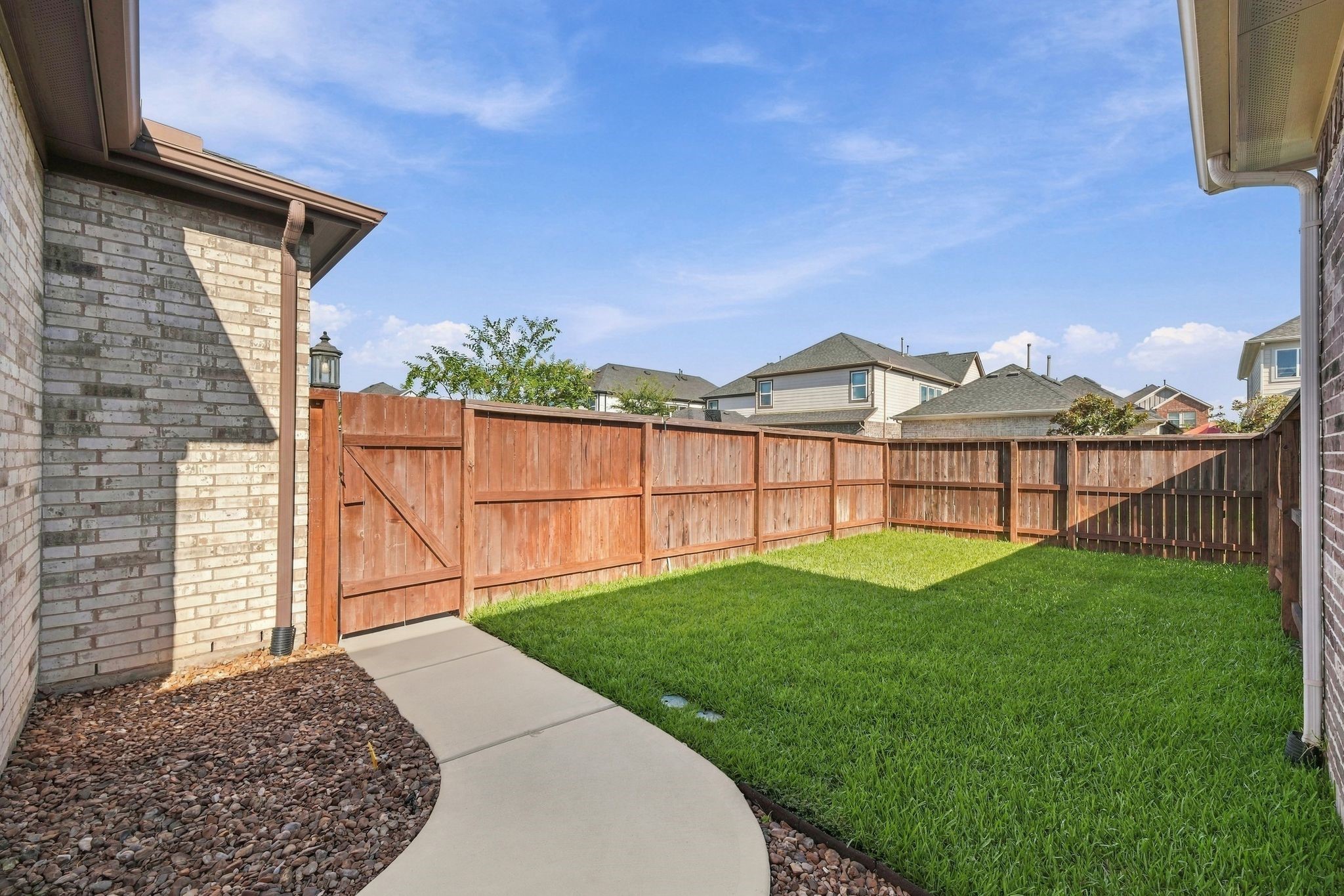 A private backyard framed by a wood fence. Room to grill, garden, or just sit outside.