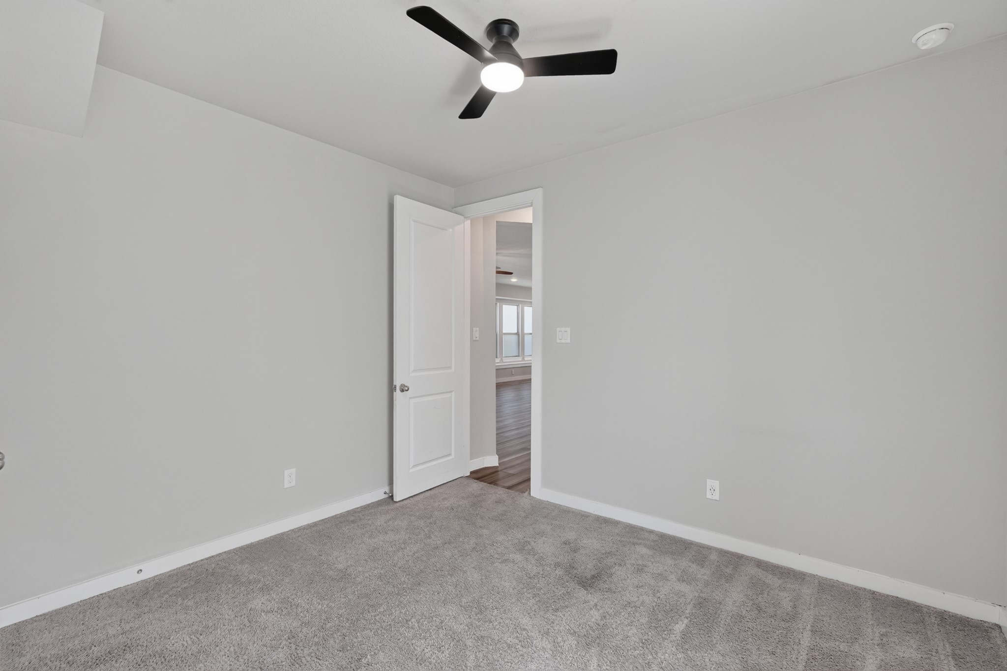 Another secondary bedroom with soft carpet, a ceiling fan, and a neutral palette that makes decorating simple and personal. Clean, bright, and move-in ready  this versatile room adapts easily to whatever purpose your household needs most right now.