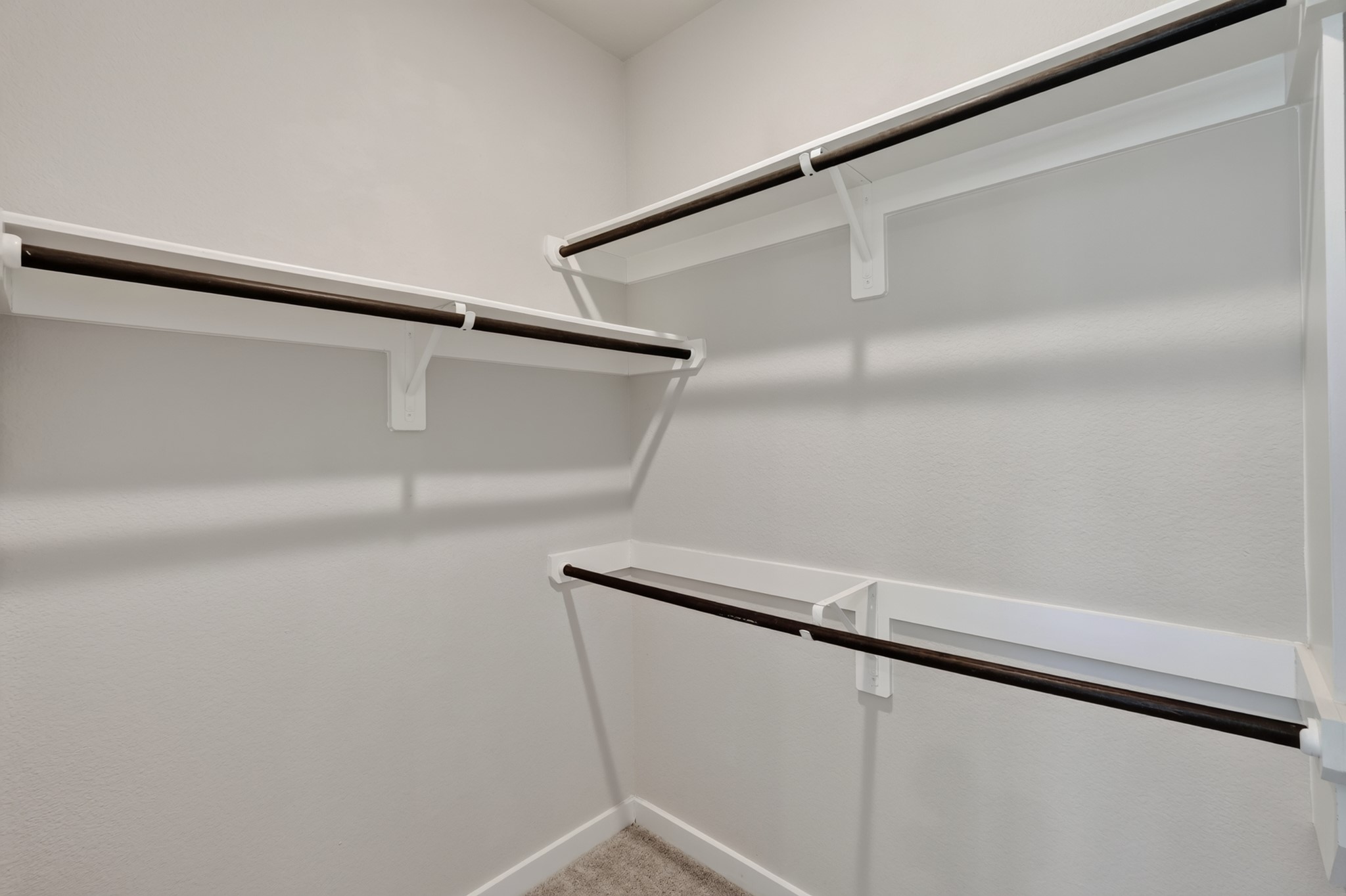 The primary suite's walk-in closet provides generous rod space and room for custom shelving  a practical luxury that makes everyday organization effortless. Large enough to accommodate an extensive wardrobe with ease, comfort, and lasting everyday style.