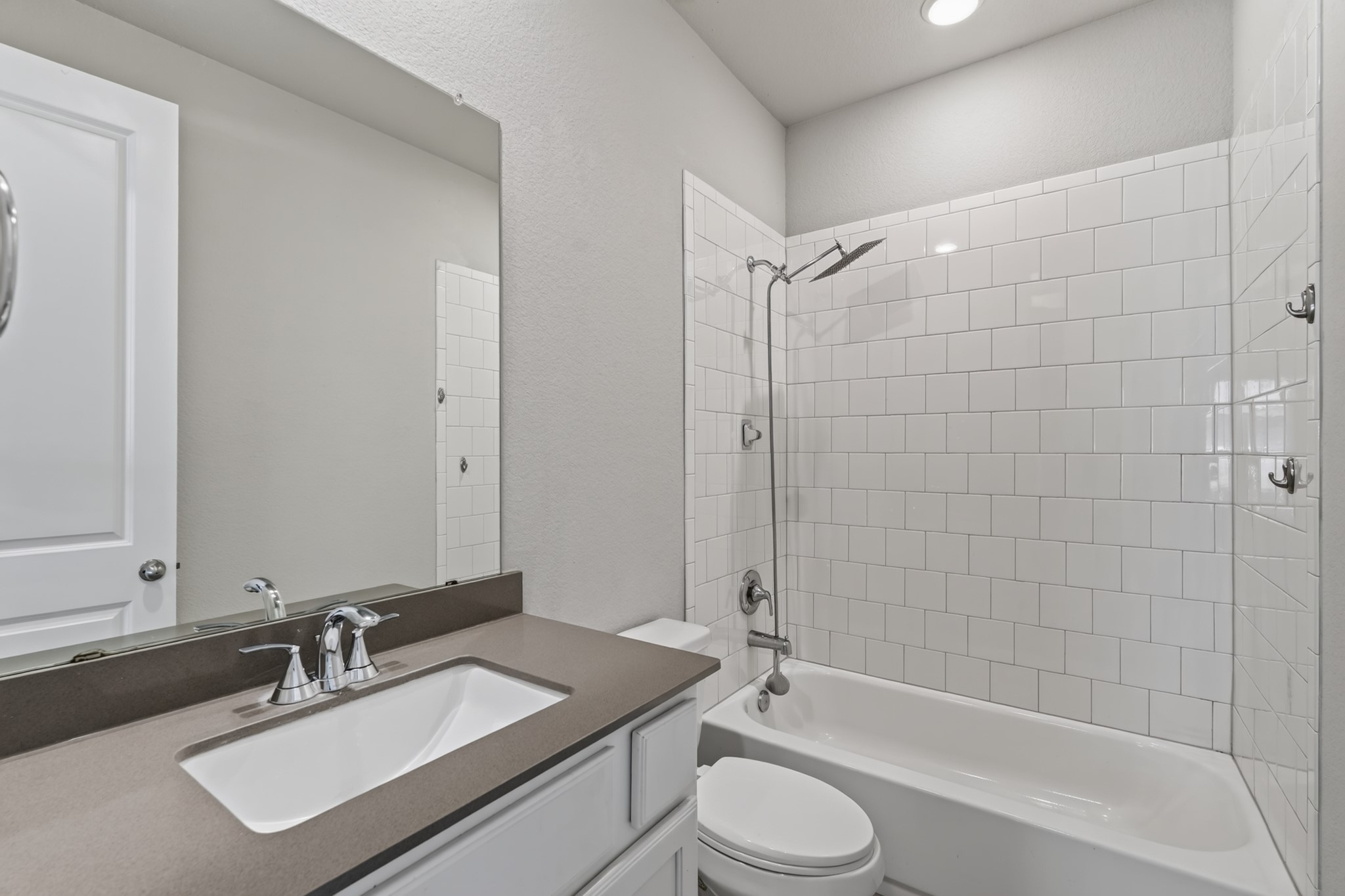 Convenient full bathroom near the secondary bedrooms  featuring a vanity with sink, toilet, and clean neutral finishes. Functional design and easy-care surfaces make this bathroom both practical for daily use and refreshingly simple to keep maintained.