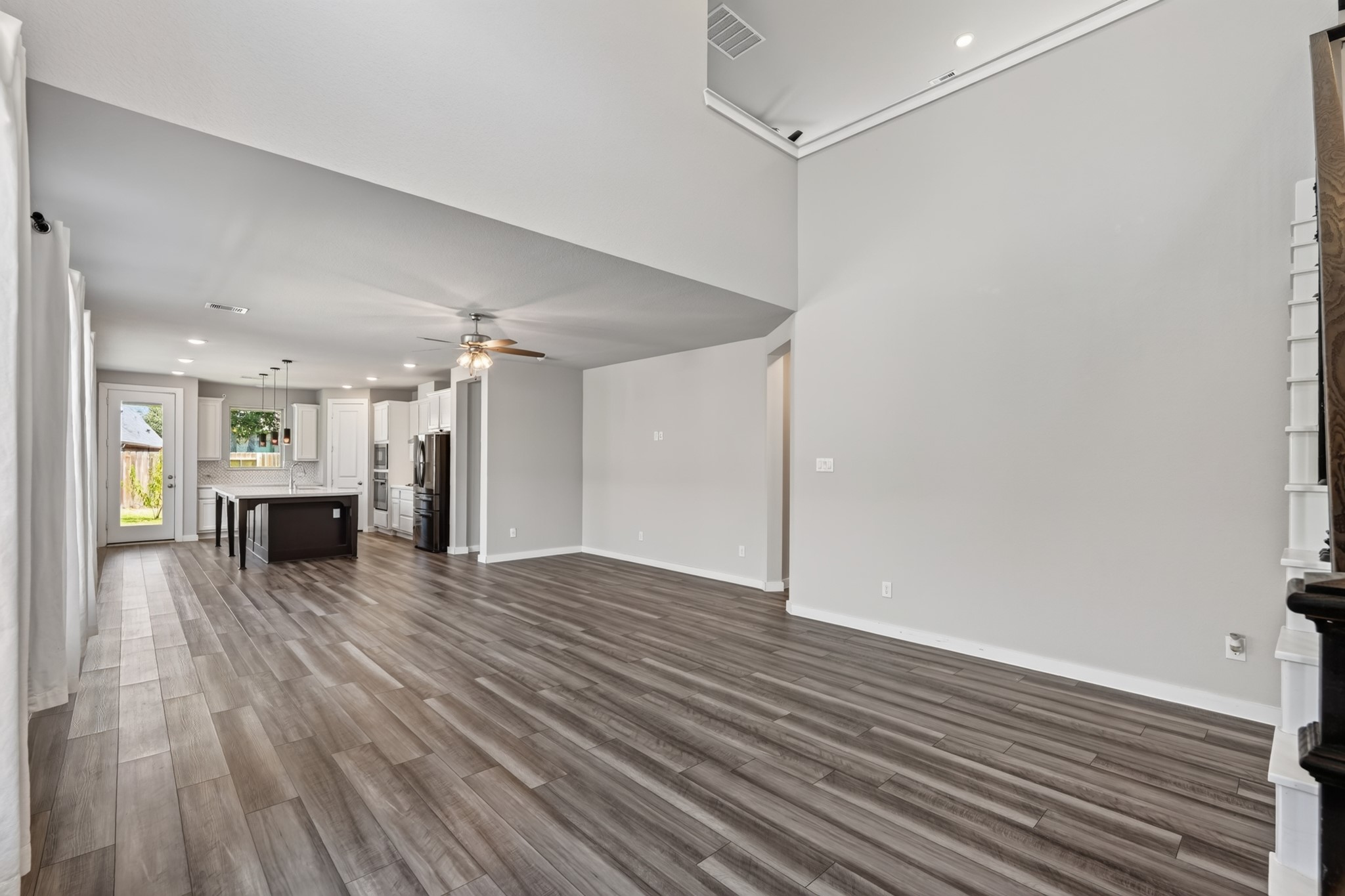 The open-concept main living area flows beautifully from the foyer  dark hardwood-style floors, an abundance of natural light, and an expansive layout that keeps you connected to every part of the home. Airy, inviting, and perfectly move-in ready.