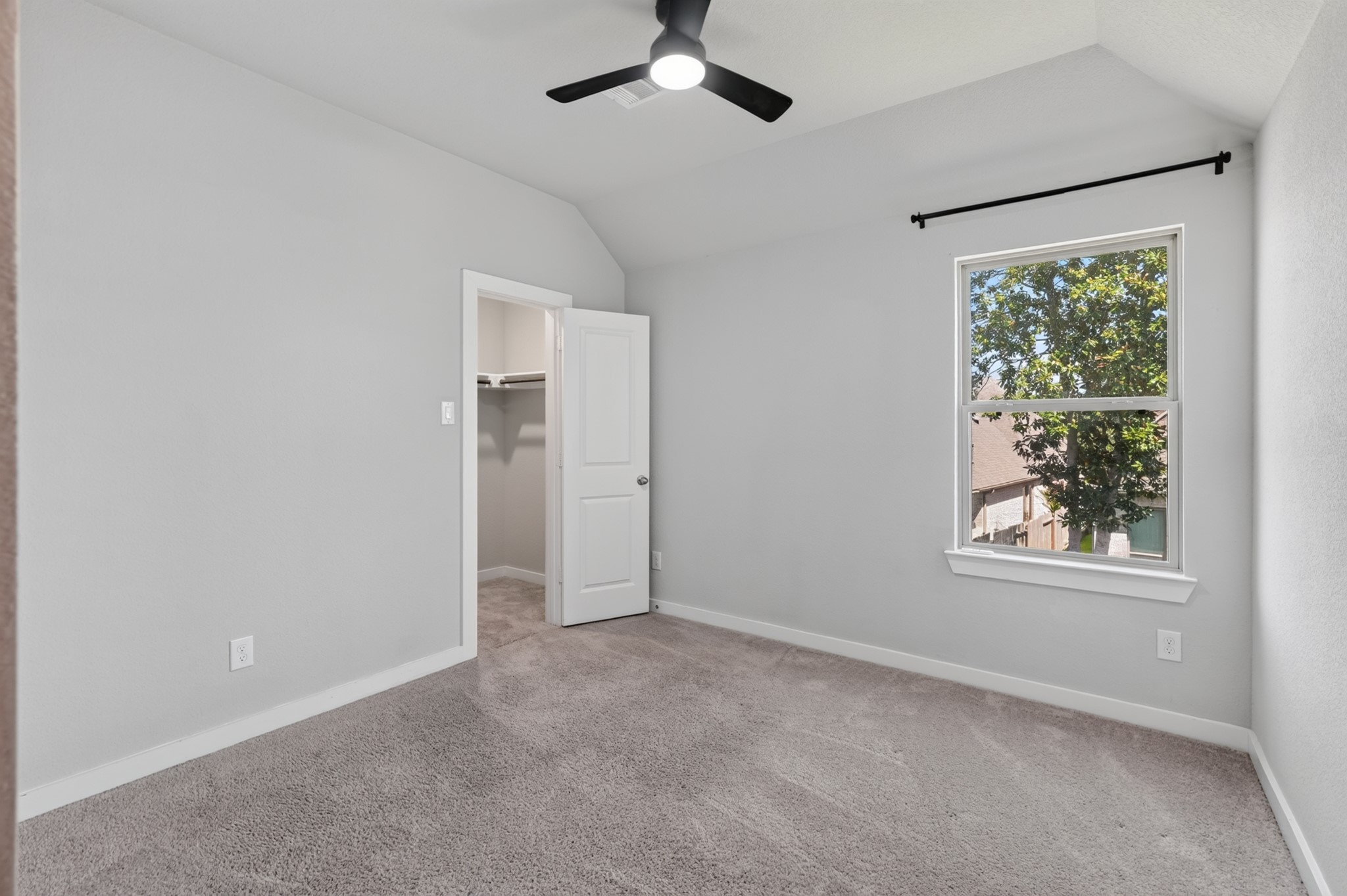 Another secondary bedroom with a ceiling fan, plush carpet, and natural light from the window. Whether used as a kids' room, guest room, or home office, this bright and clean space offers the comfort and versatility needed for every stage of family life.