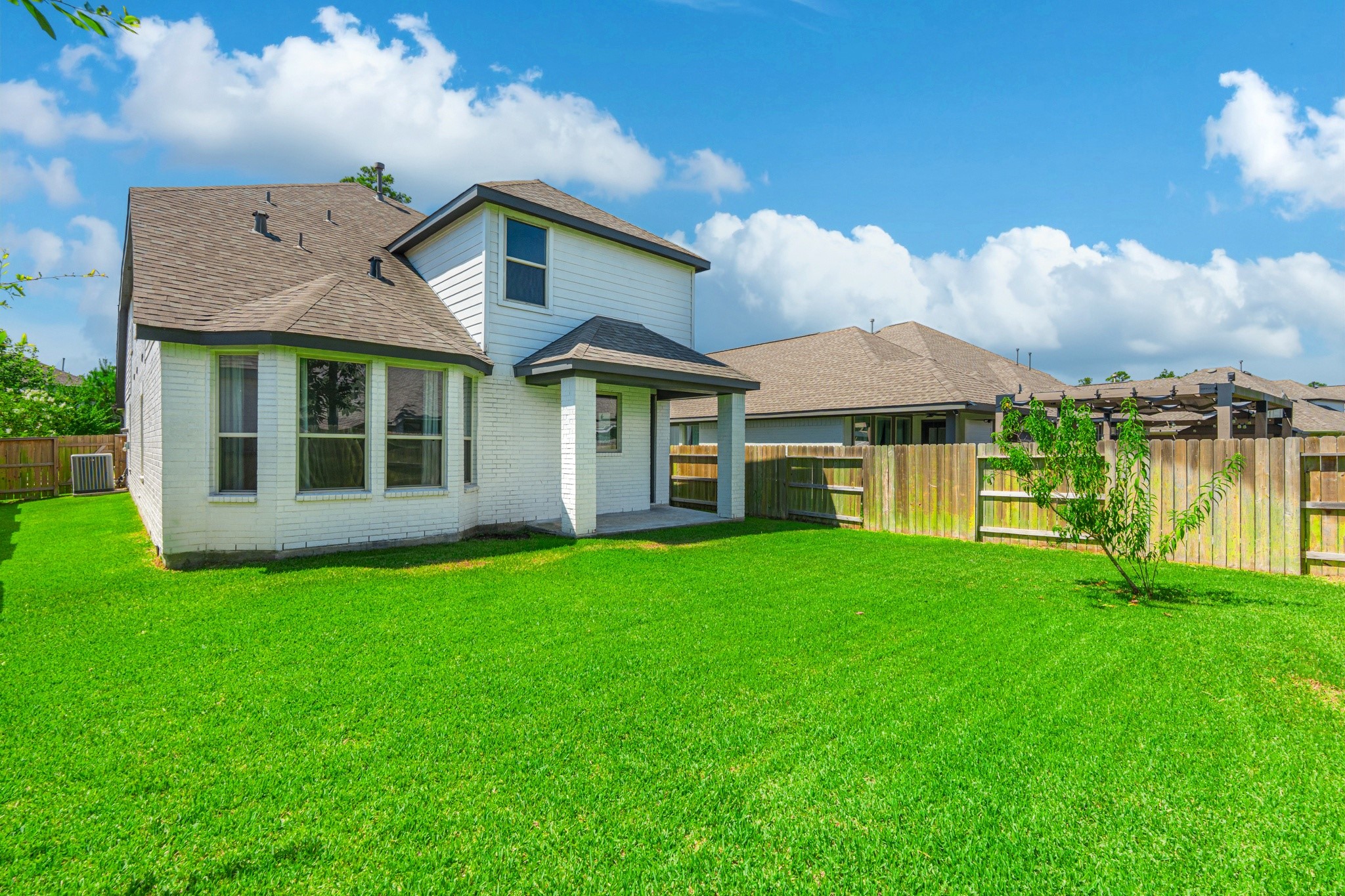 Another rear exterior view highlights the generous green backyard and the home's clean, well-maintained exterior. Plenty of space to add a patio set, playset, or garden  this yard is ready for whatever outdoor vision you bring to your new home.