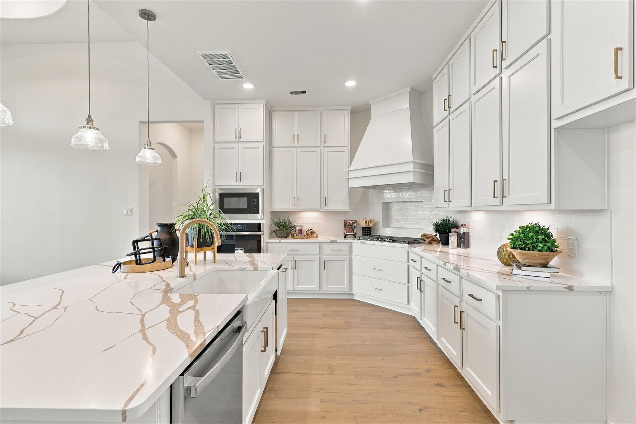 BEAUTIFUL DETAILS & EXCEPTIONAL FUNCTIONALITY! This STUNNING kitchen showcases gorgeous QUARTZ countertops, elegant white cabinetry, and generous workspace for preparing your favorite meals! Abundant cabinets provide convenient storage, while the bright finishes and thoughtfully designed layout create a fresh, timeless look! A WONDERFUL space for everyday cooking and entertaining! **Photo is Virtually Staged**