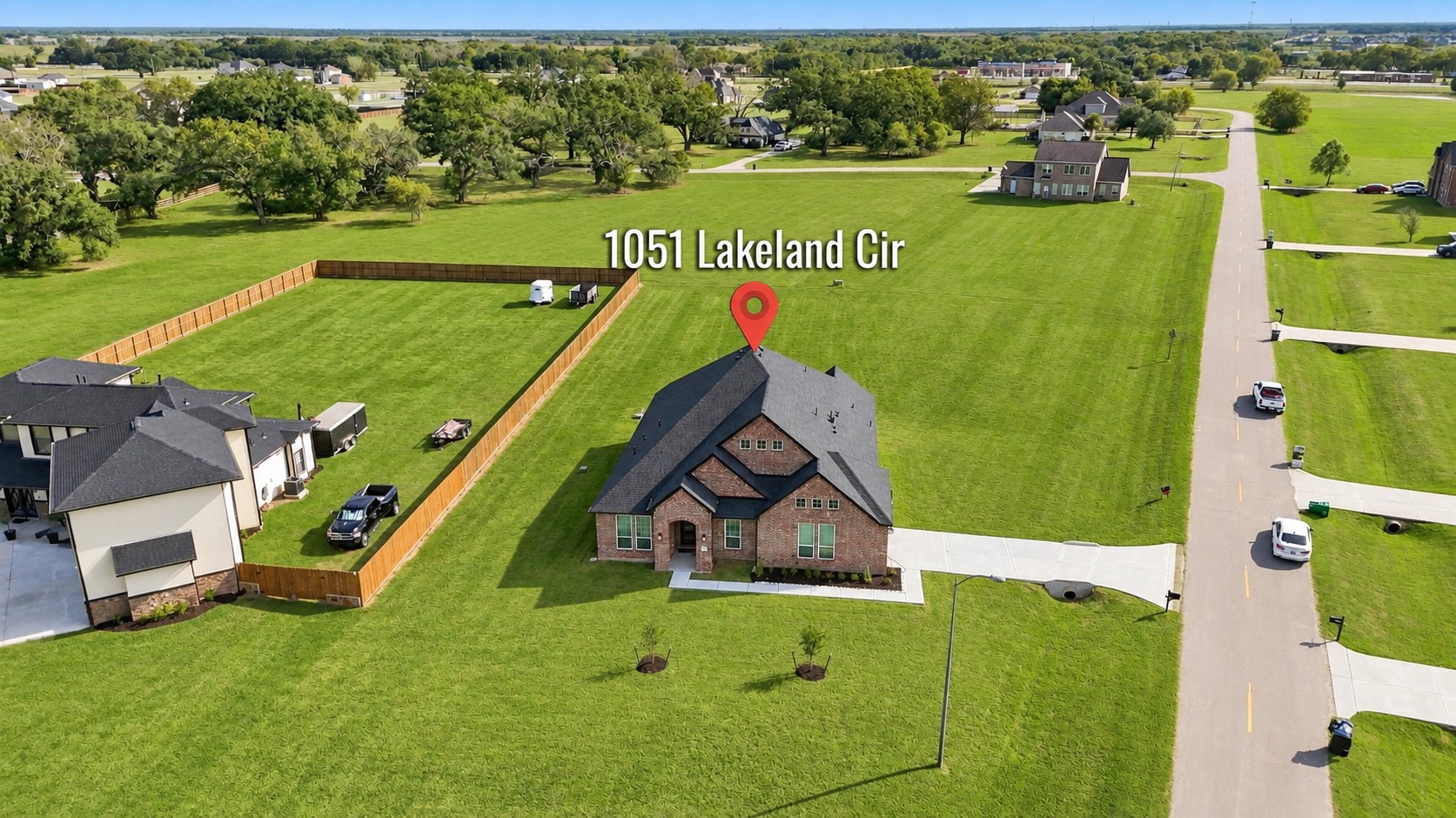 A CLOSER LOOK AT THIS BEAUTIFUL PROPERTY! This aerial view showcases the home's attractive brick exterior, welcoming front lawn, and position along the neighborhood street! The expansive lot and surrounding open green spaces highlight the property's spacious setting! A BEAUTIFUL home with room to enjoy the outdoors!