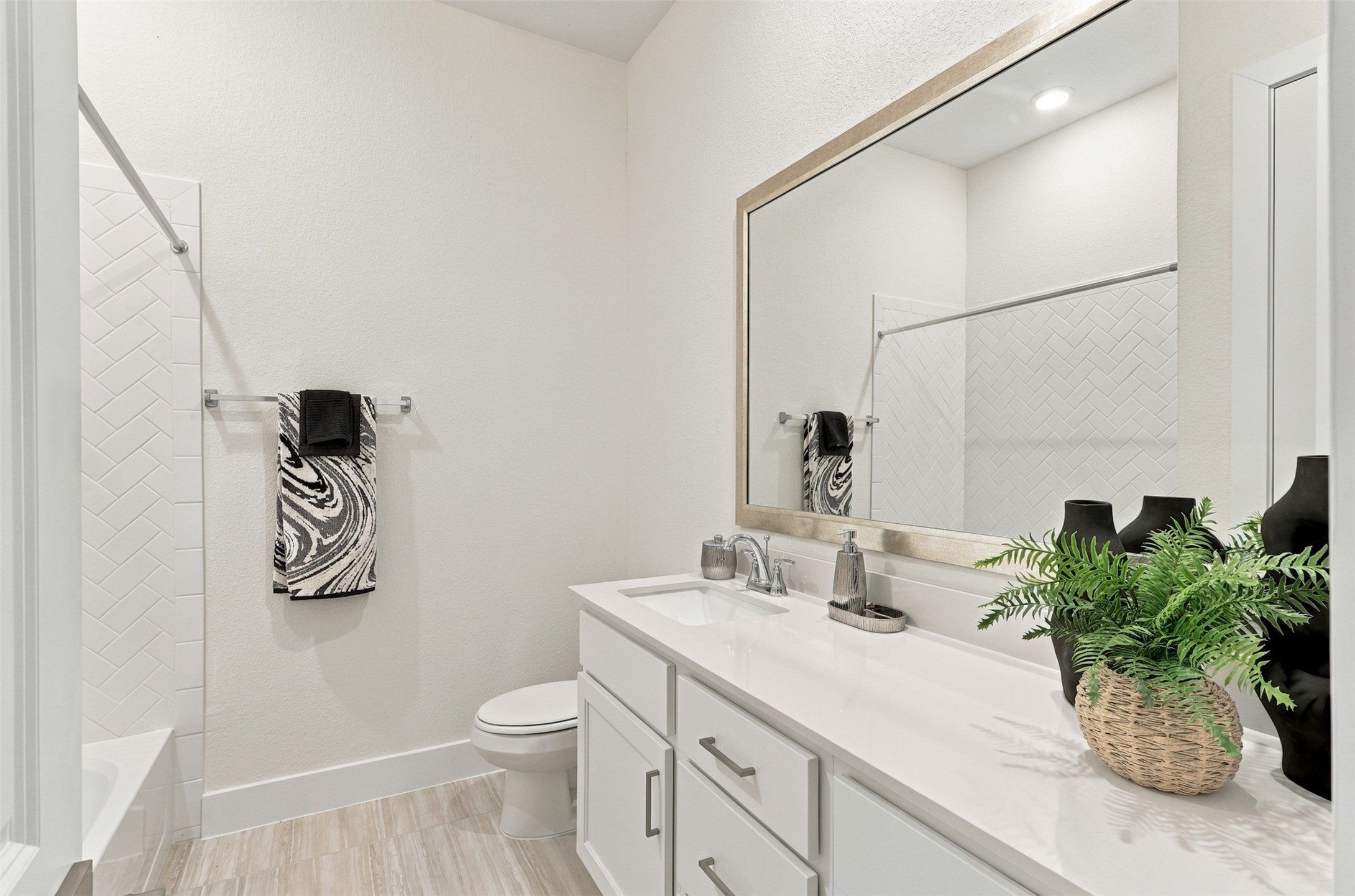 EVERYDAY LUXURY WITH A TOUCH OF ELEGANCE! This BEAUTIFUL SECONDARY BATHROOM is designed to IMPRESS! Enjoy a SPACIOUS VANITY showcasing GORGEOUS QUARTZ COUNTERTOPS, a DEEP UNDERMOUNT SINK & an abundance of CABINET AND DRAWER STORAGE to keep everything beautifully organized! Notice the STUNNING LARGE-FORMAT TILE FLOORING that adds a sophisticated, custom touch! And the finishing detail? An ELEGANT DESIGNER-FRAMED MIRROR for that touch of class!