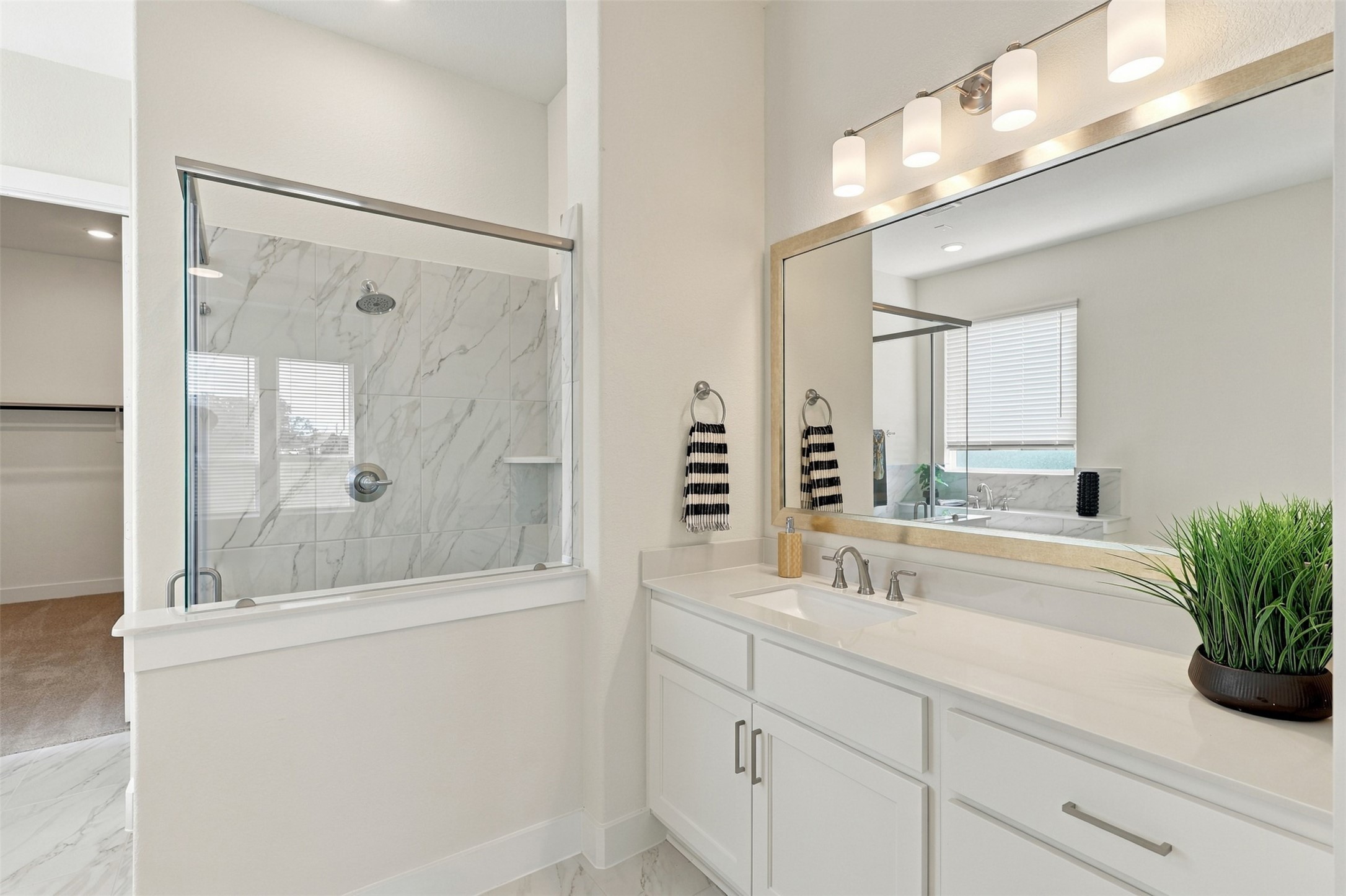 YOUR SPA-INSPIRED PRIMARY BATHROOM AWAITS! Start each morning surrounded by BEAUTY, COMFORT & EVERYDAY LUXURY! This STUNNING RETREAT showcases an EXTENDED VANITY with GORGEOUS QUARTZ COUNTERTOPS, a DEEP UNDERMOUNT SINK & an ELEGANT DESIGNER-FRAMED MIRROR! Notice the ABUNDANCE OF CABINETS & DRAWERS offering WONDERFUL STORAGE to keep everything beautifully organized! A PERFECT BLEND OF STYLE, FUNCTION & SOPHISTICATION! YOUR OWN PRIVATE ESCAPE!
