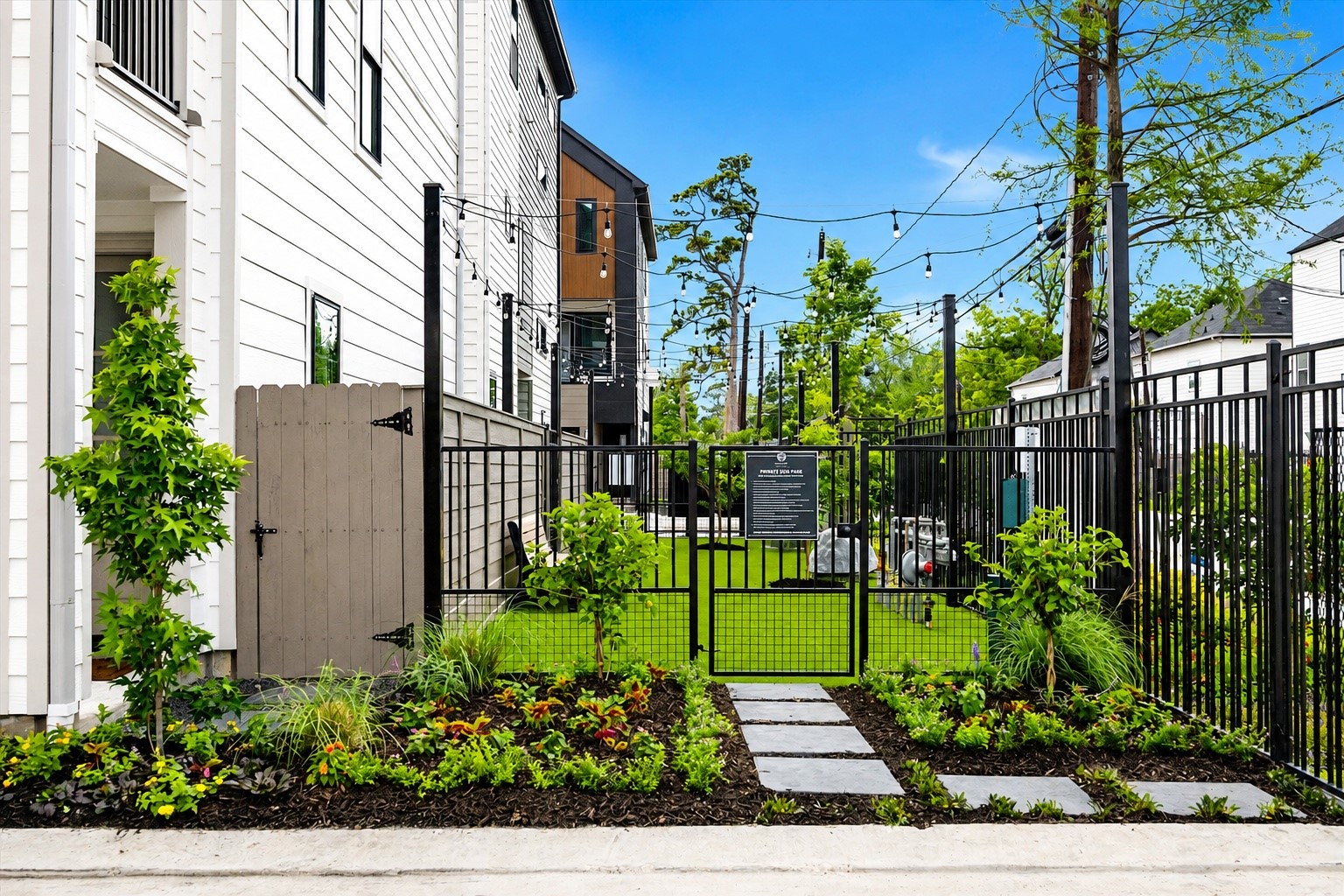 Landscaped outdoor space with turf, paver walkways, and gated privacy Landscaped outdoor space with turf, paver walkways, and gated privacy