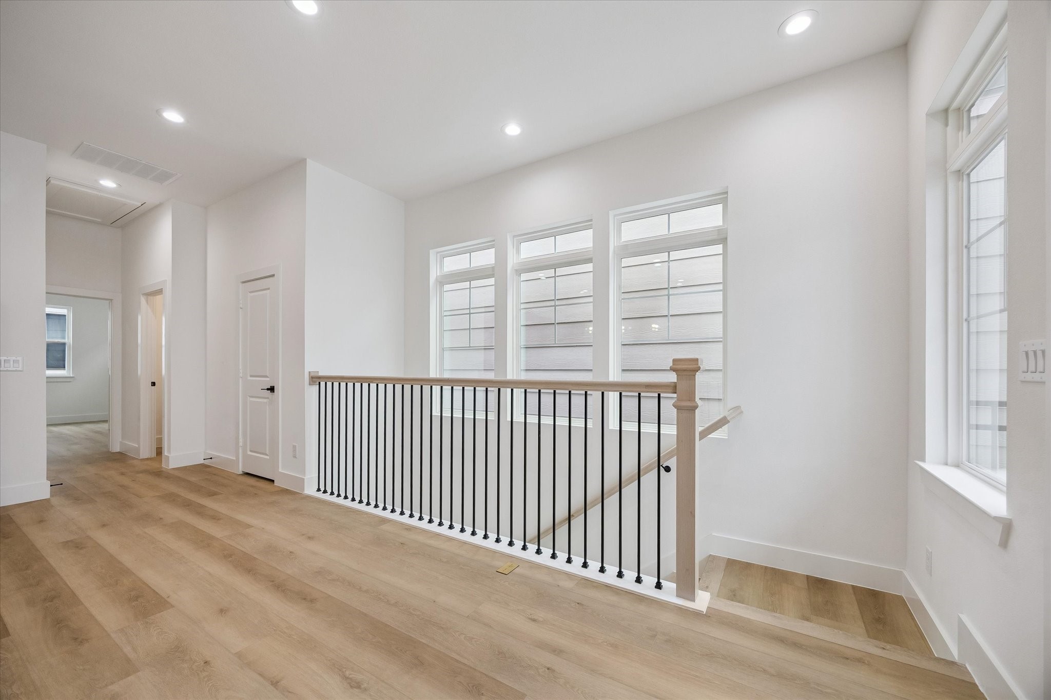 Open second-floor gathering space with polished flooring and soft natural light