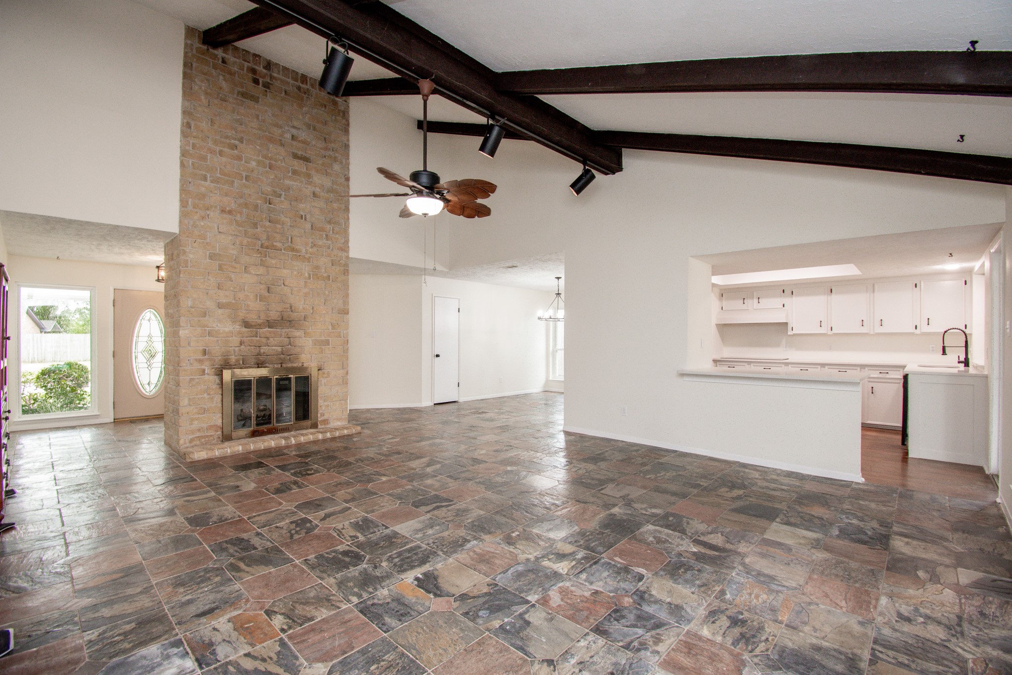 Living room features slate tile floors, wood beams in the vaulted ceiling!