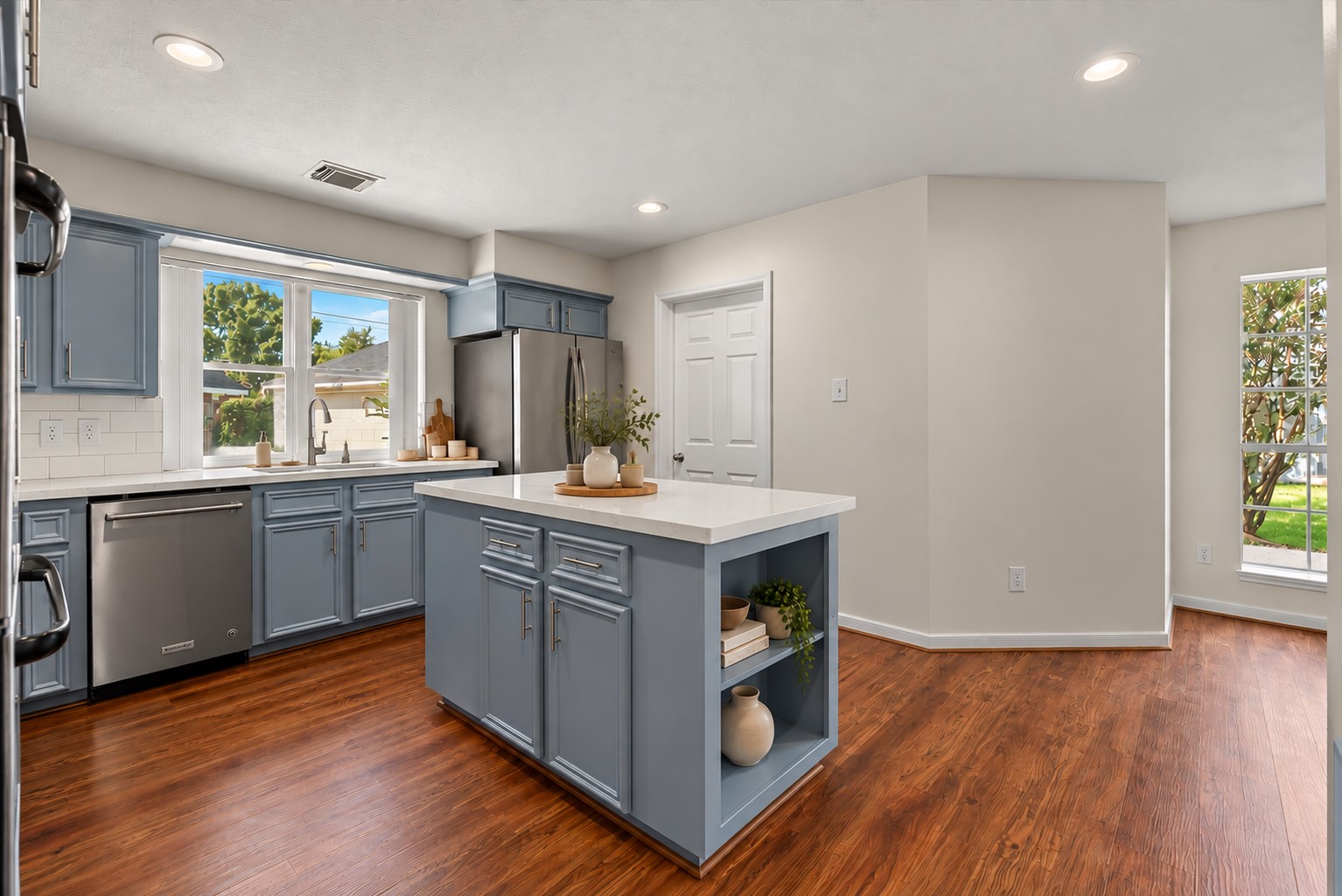 The updated chef-inspired island kitchen showcases extensive countertops, rich solid wood cabinetry, stainless steel appliances and double ovens.