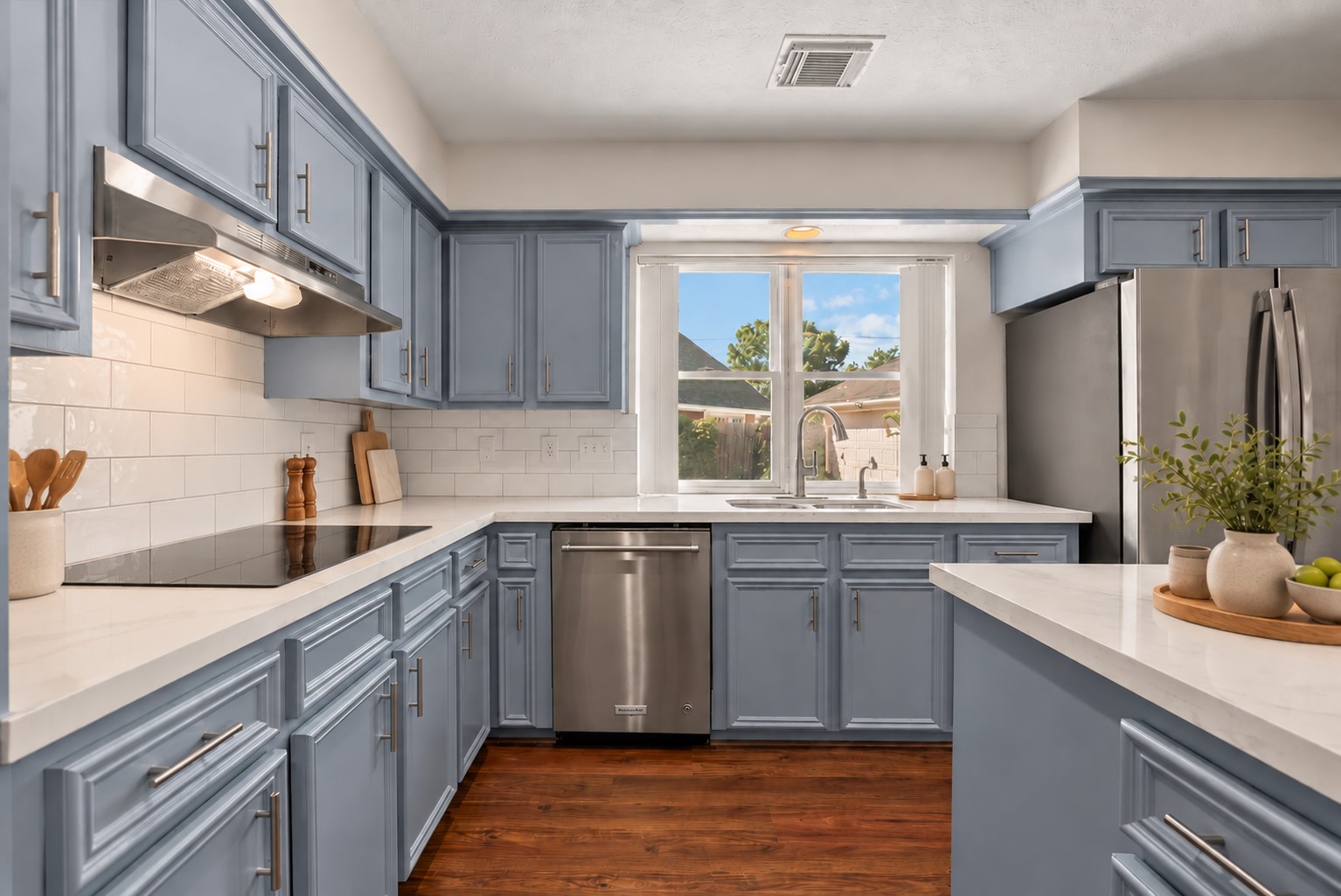The updated chef-inspired island kitchen showcases extensive countertops, rich solid wood cabinetry, stainless steel appliances and double ovens.