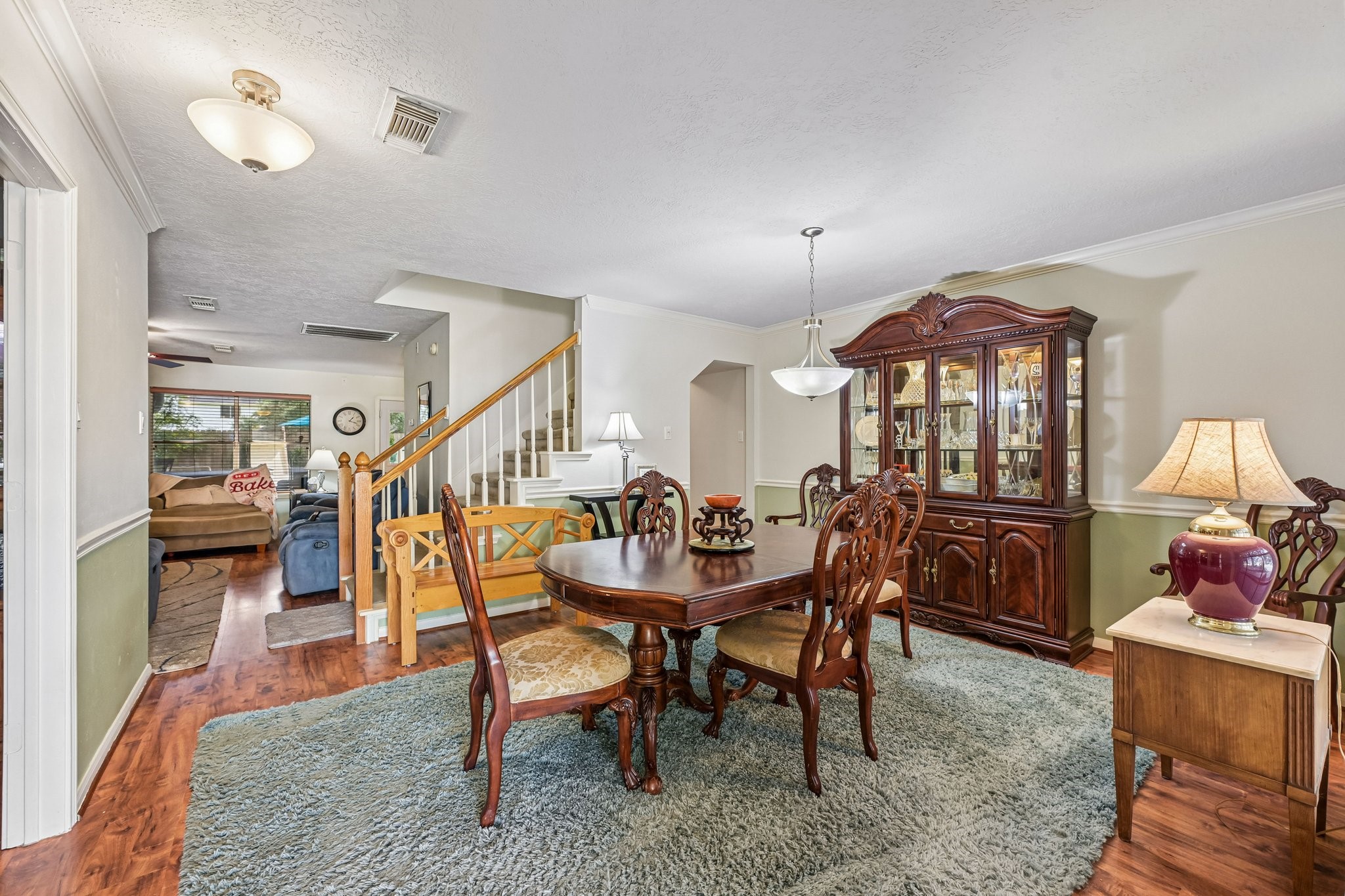 Elegant formal dining room featuring traditional chair rail molding, direct open view to the main living area, and adjacent staircase.