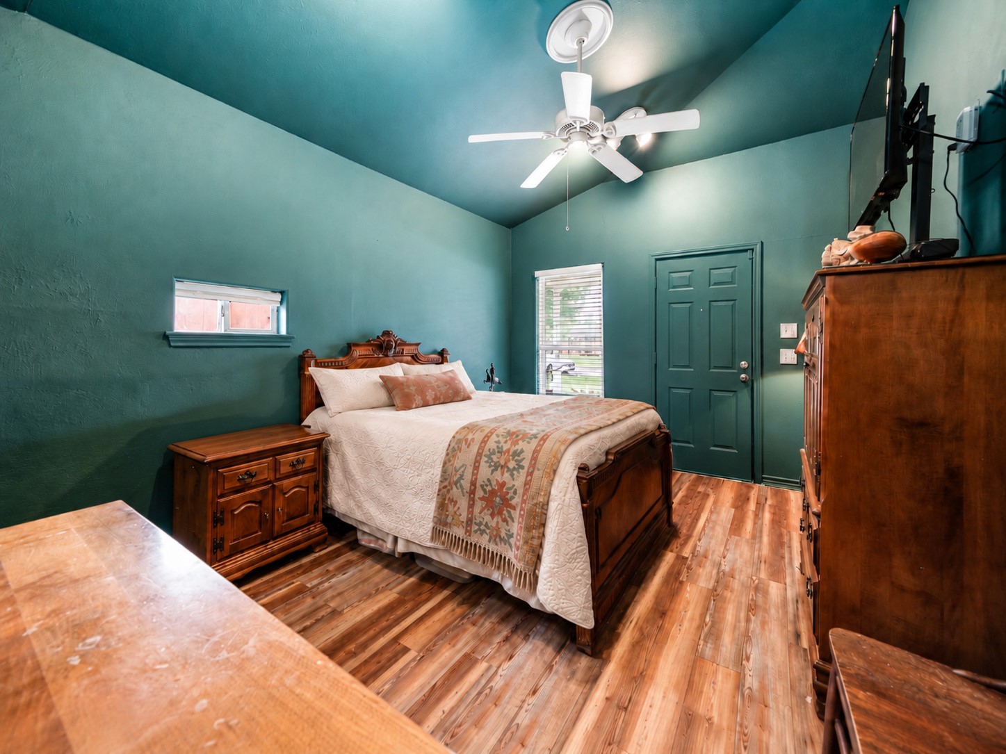 Guest suite with ceiling fan and room for a desk or sitting area.
