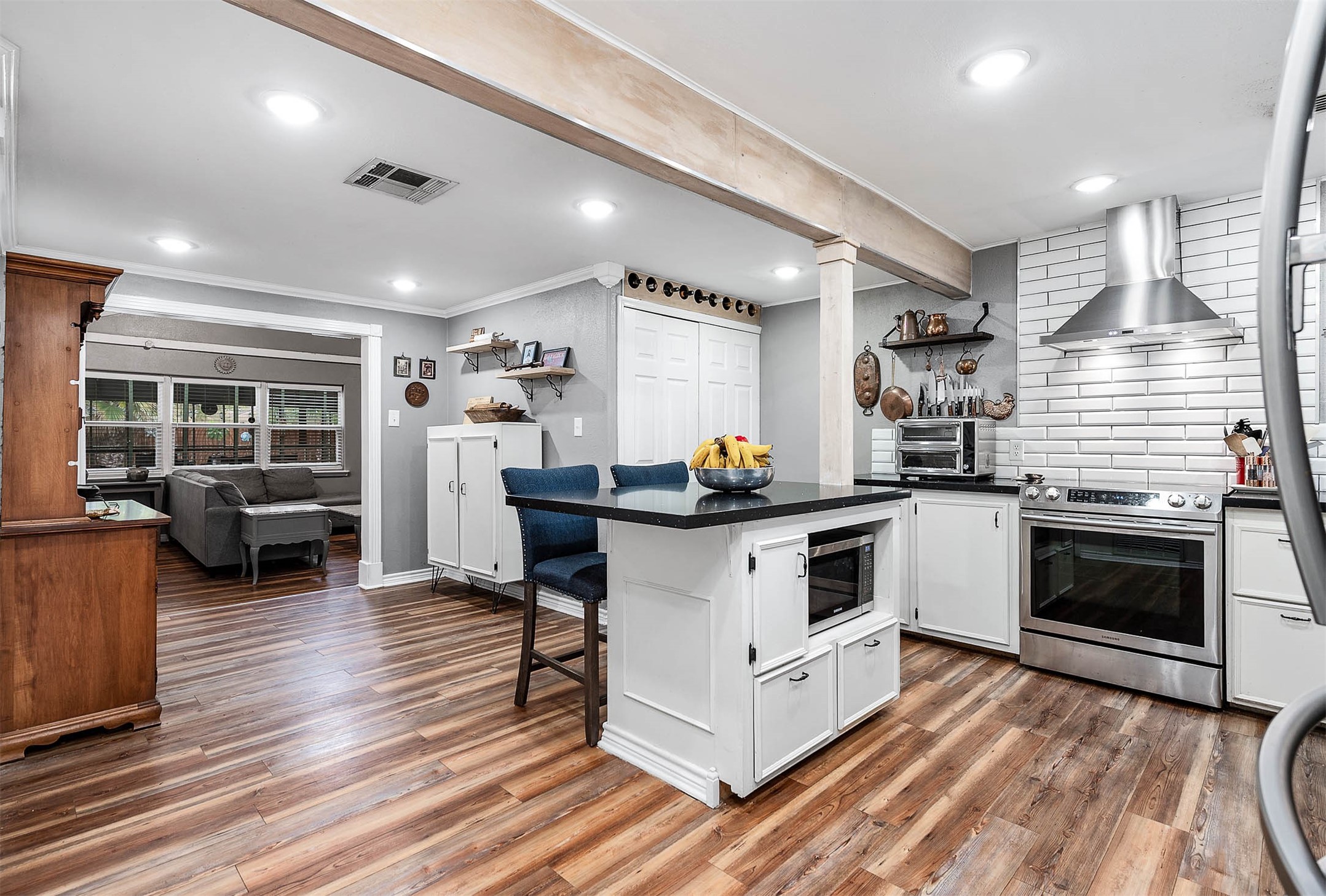 Updated kitchen with granite counters, stainless appliances, center island and open shelving.