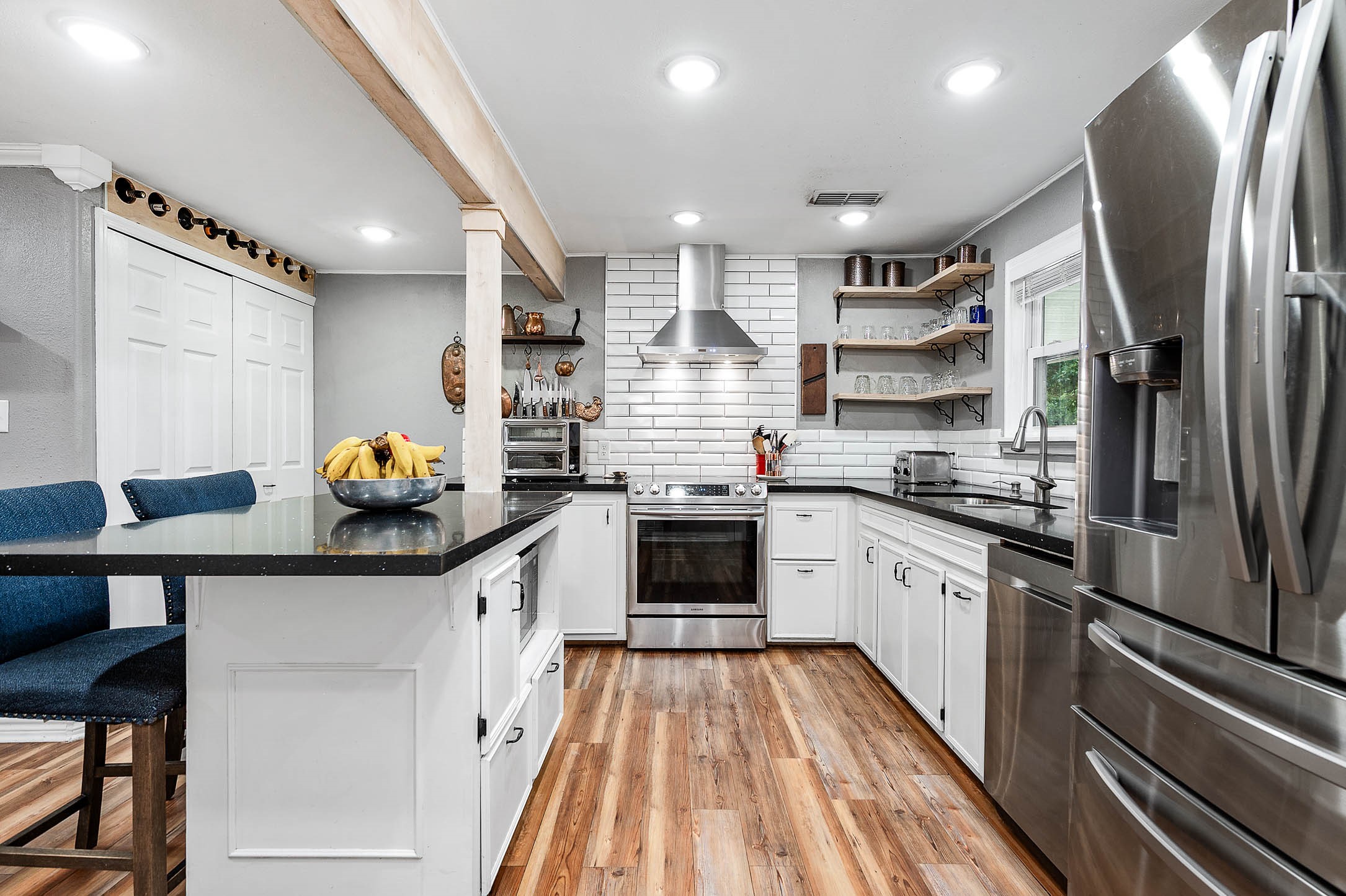 Kitchen island with seating and generous cabinet storage; refrigerator conveys.