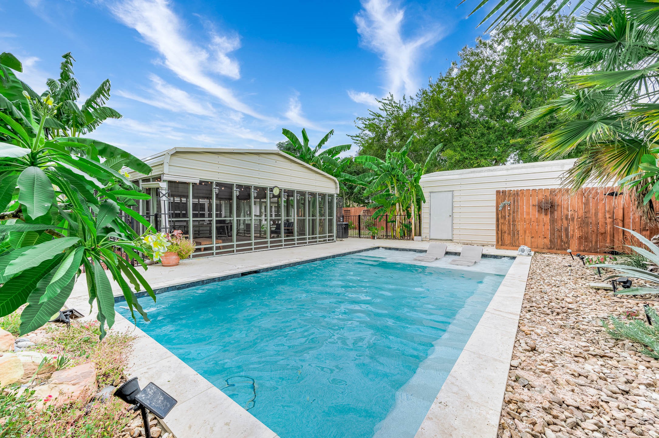 Pool and metal storage shed in the fenced backyard.