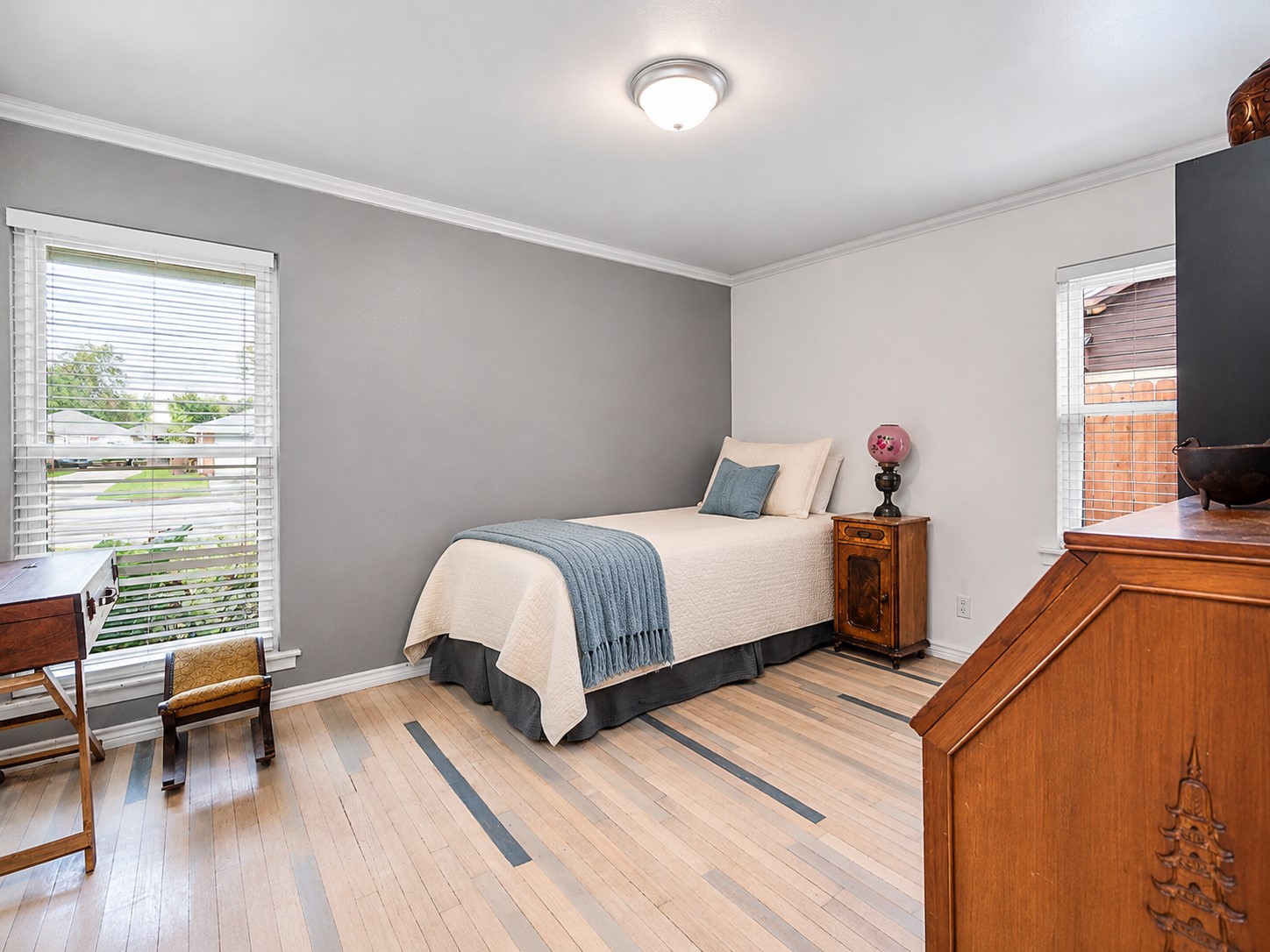 Secondary bedroom with crown molding and natural light.