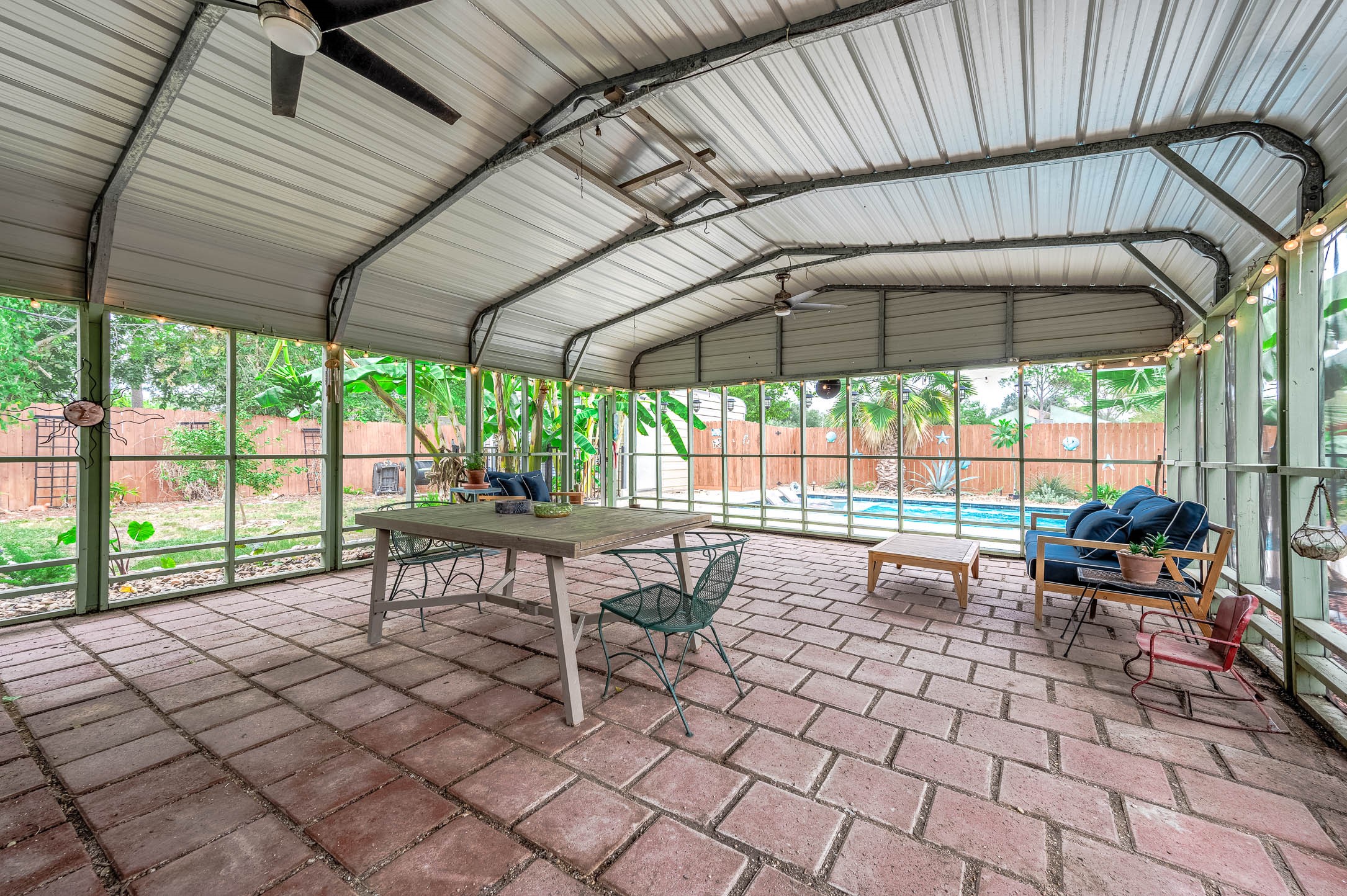 Screened porch with ceiling fans and room for dining and lounging.