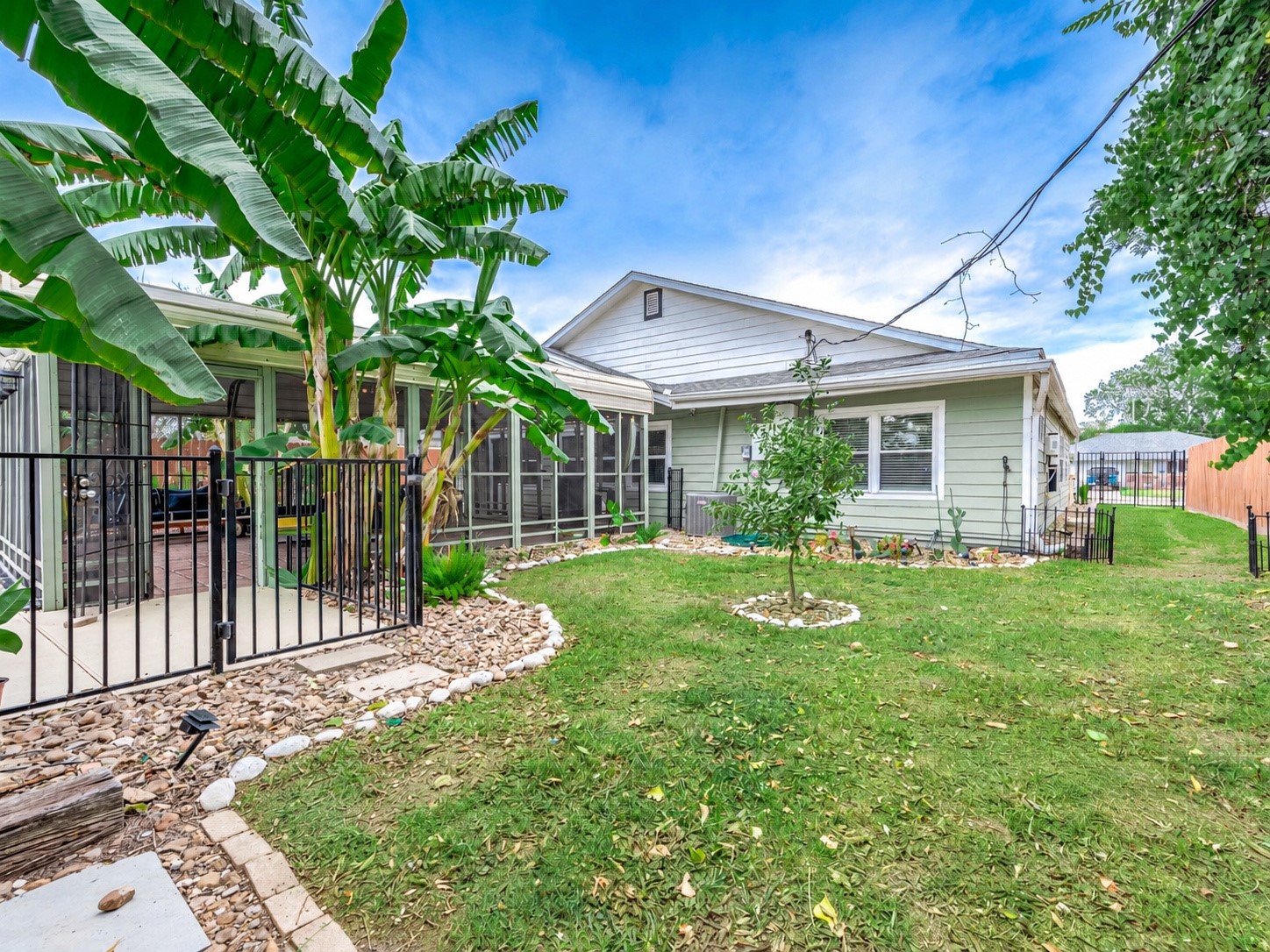 Backyard with metal pool fencing and open grass area.