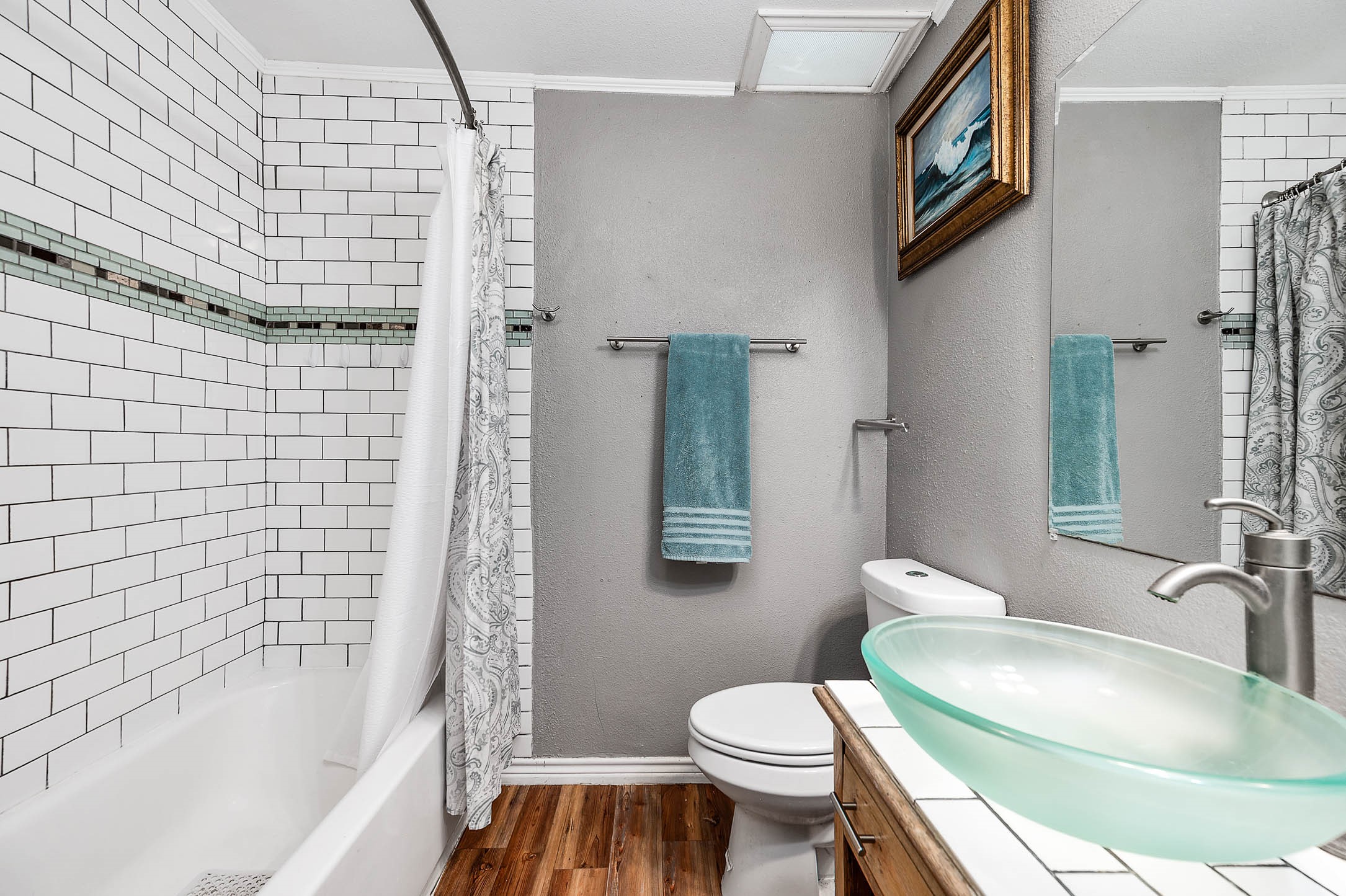 Primary bath with tub and tiled surround.