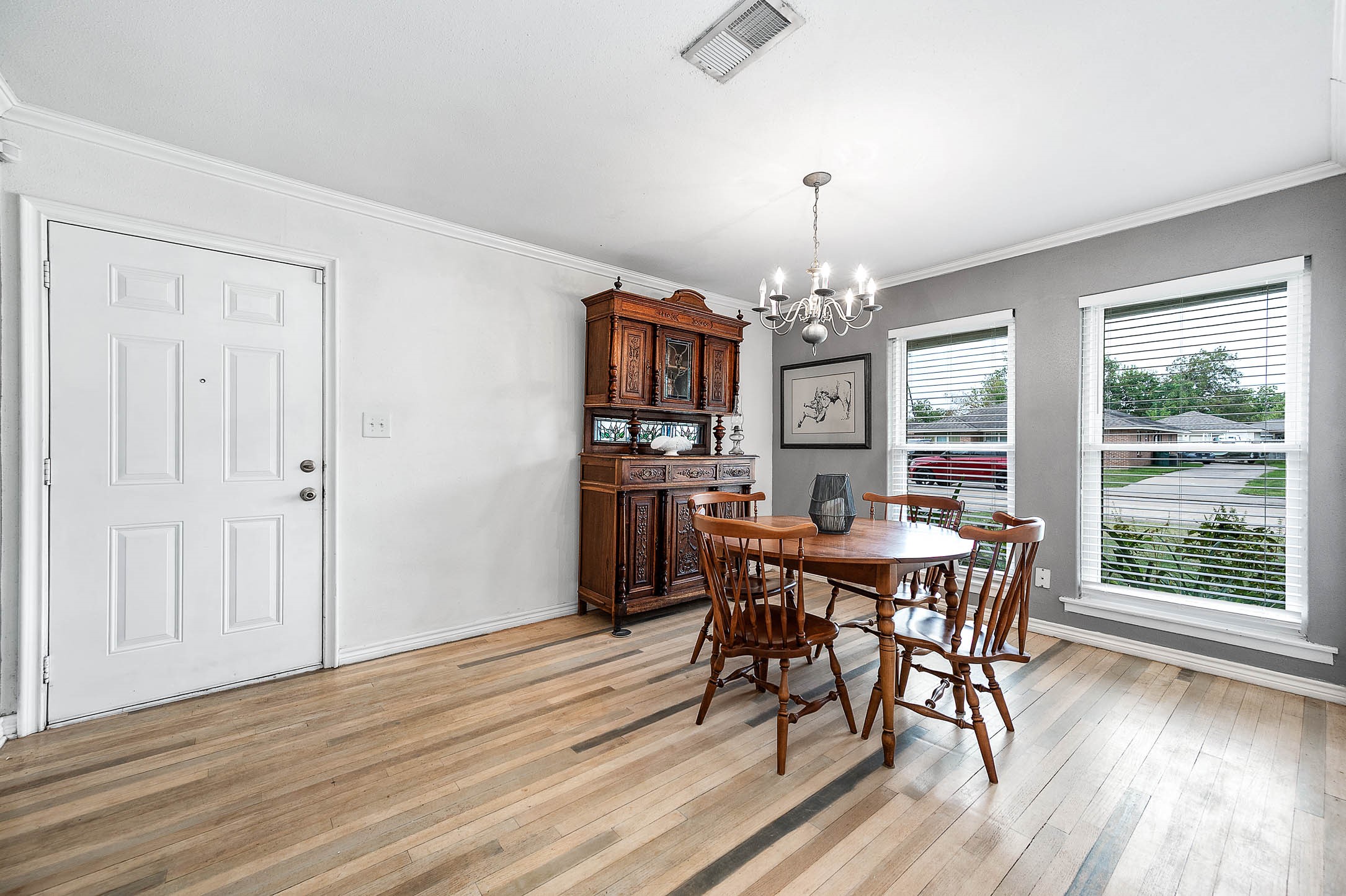 Front formal dining room with chandelier and crown molding - also works as a study or flex space.