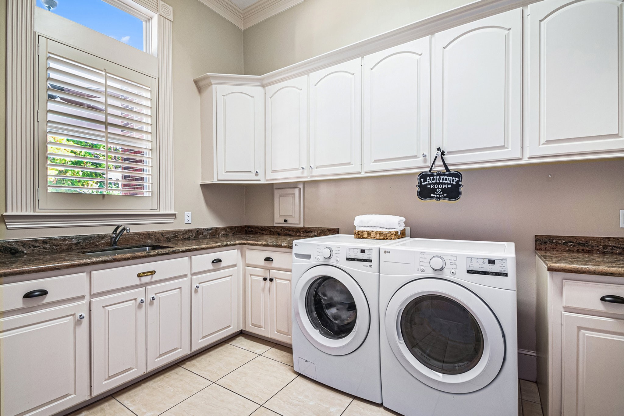This astonishing laundry room has ample storage space, an extra sink, and a laundry shoot!