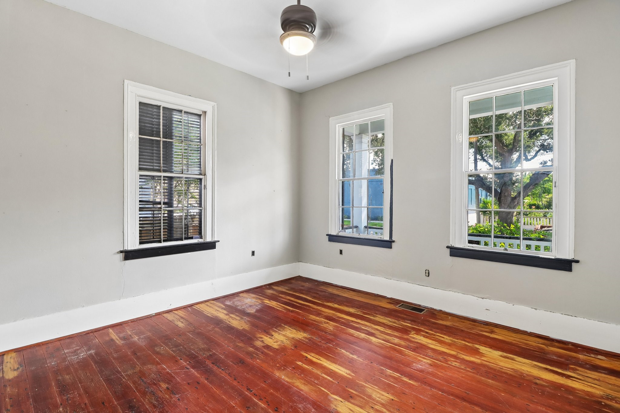 Wood flooring, tall windows and detailed trim in one of the homes light-filled interior rooms.