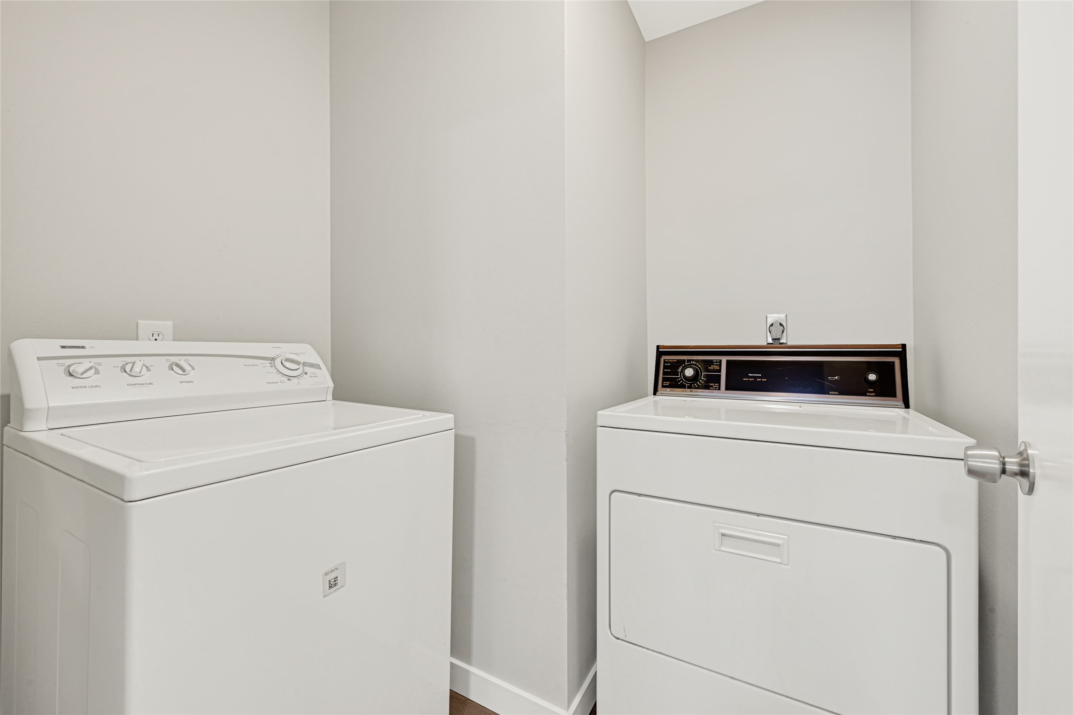 laundry room equipped with a washer and dryer, providing ample space for all your laundry needs and additional storage for cleaning supplies.