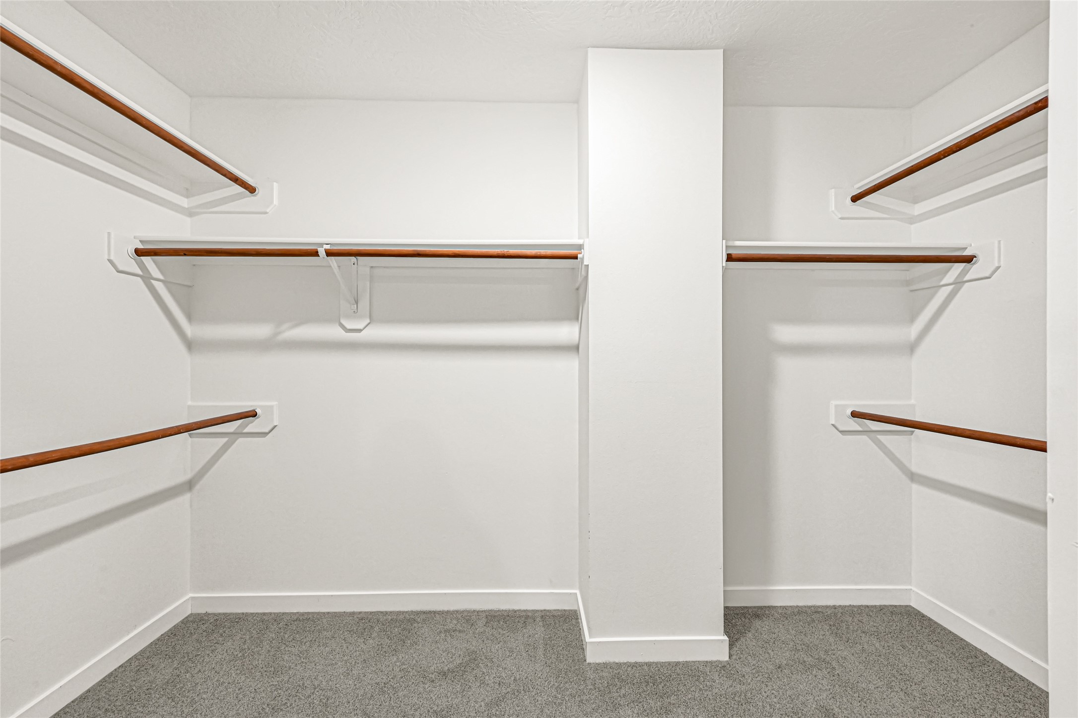 Walk-in closet featuring extensive built-in shelving, floor-to-ceiling clothing racks, and dedicated shoe organizers. This well-appointed space offers an abundance of storage for an expansive wardrobe, ensuring effortless organization and a clutter-free environment.