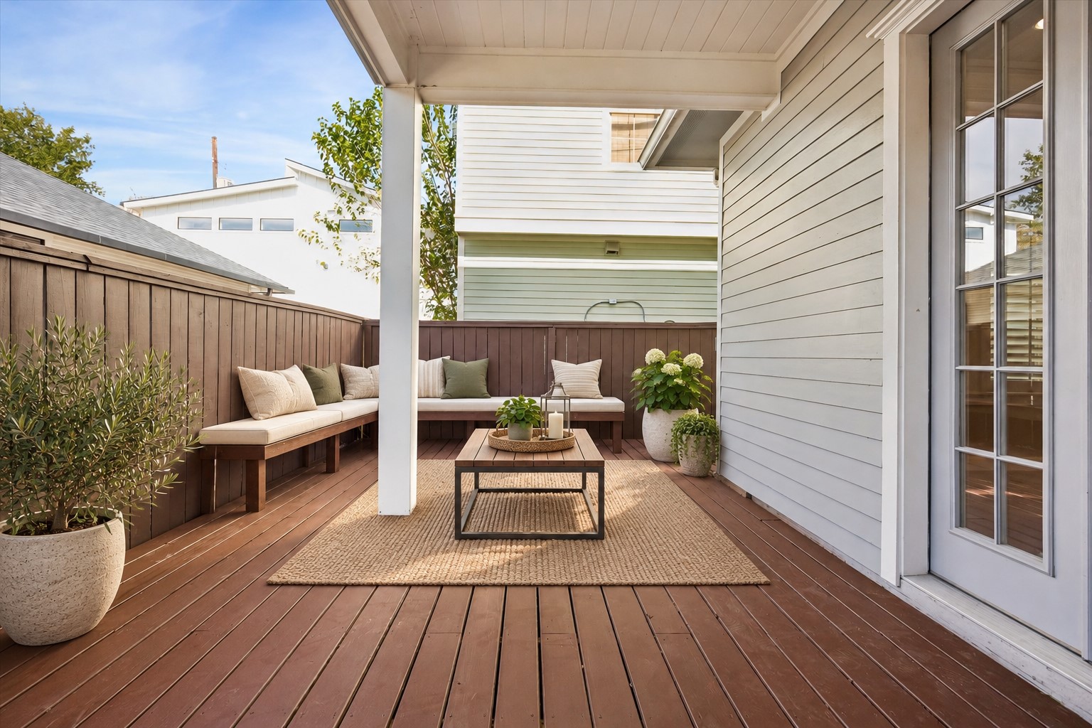 Private outdoor retreat offering a spacious wood deck with a partially covered seating area and privacy fencing, ideal for relaxing or gathering with guests. Photo is virtually staged.