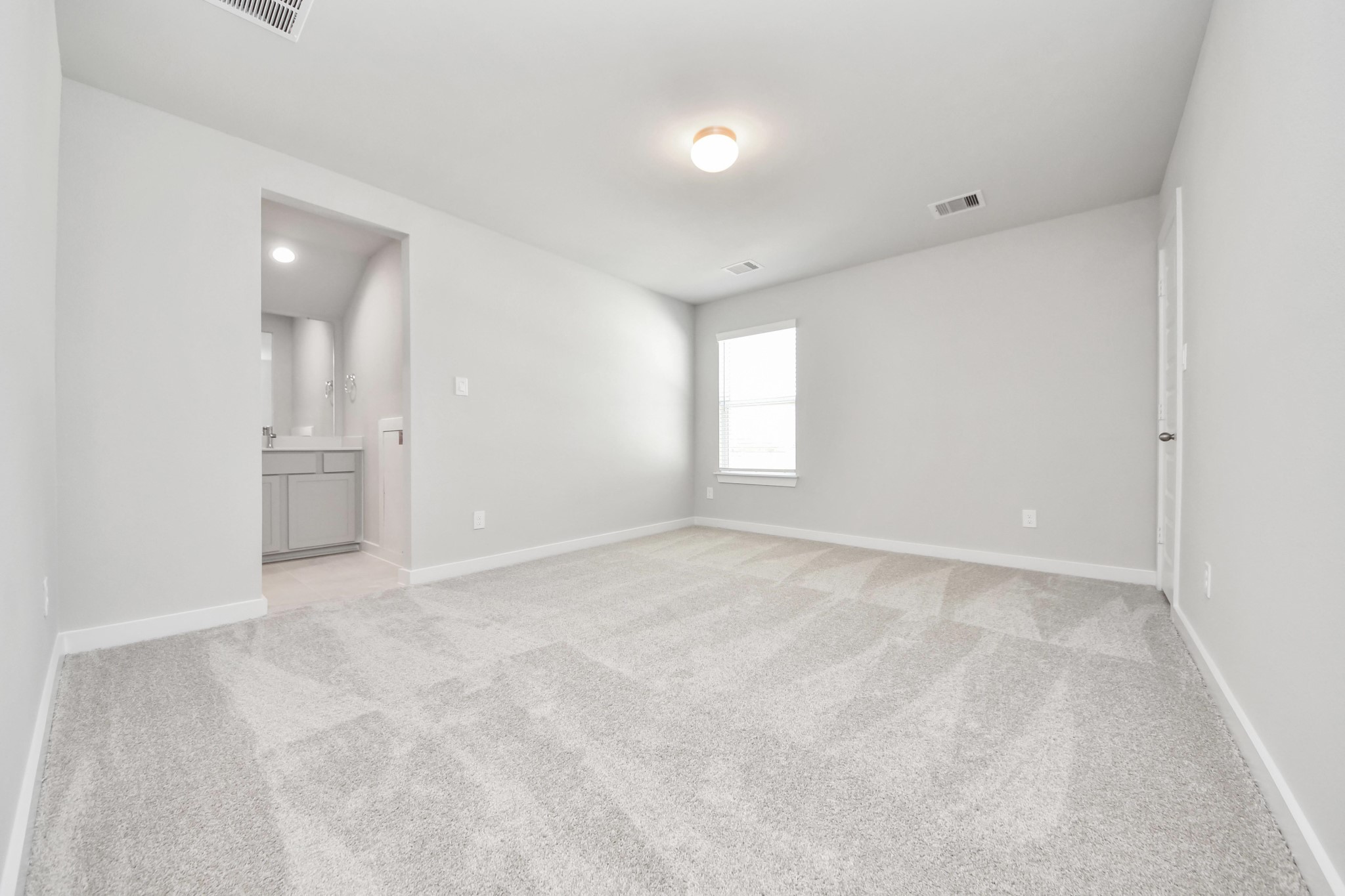 Secondary bedroom features plush carpeting, large windows that let in plenty of natural light, bright paint, and spacious closets. Sample photo of completed home with similar floor plan. Actual colors and selections may vary.
