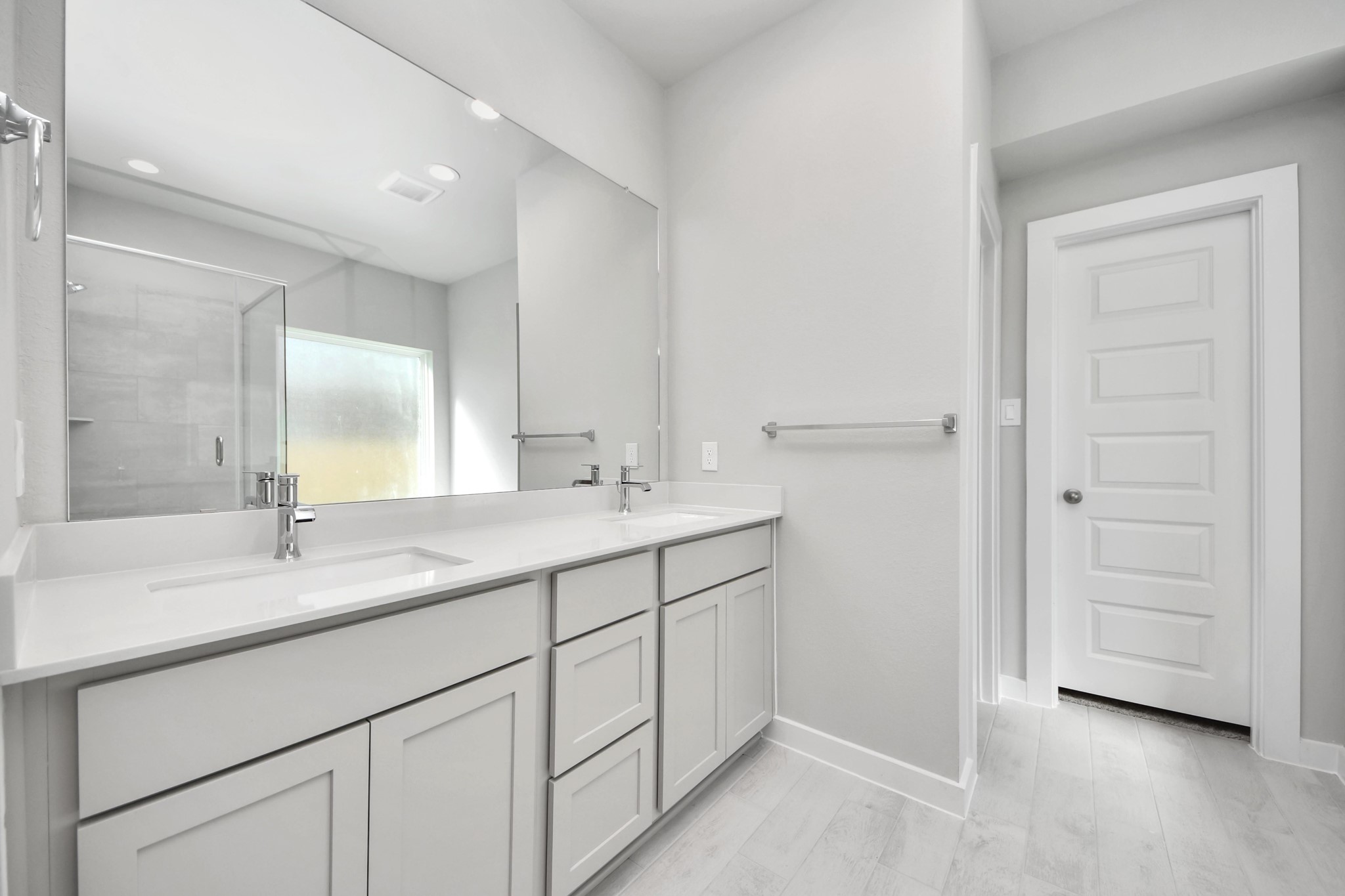 Escape to a spa-like oasis in this primary bathroom. Enjoy a walk-in shower with tile surround, a separate garden tub with custom detailing, and an elegant vanity featuring light countertops, modern hardware, and beautiful vanity lights. Experience luxury and relaxation in every detail. Sample photo of completed home with similar floor plan. Actual colors and selections may vary.